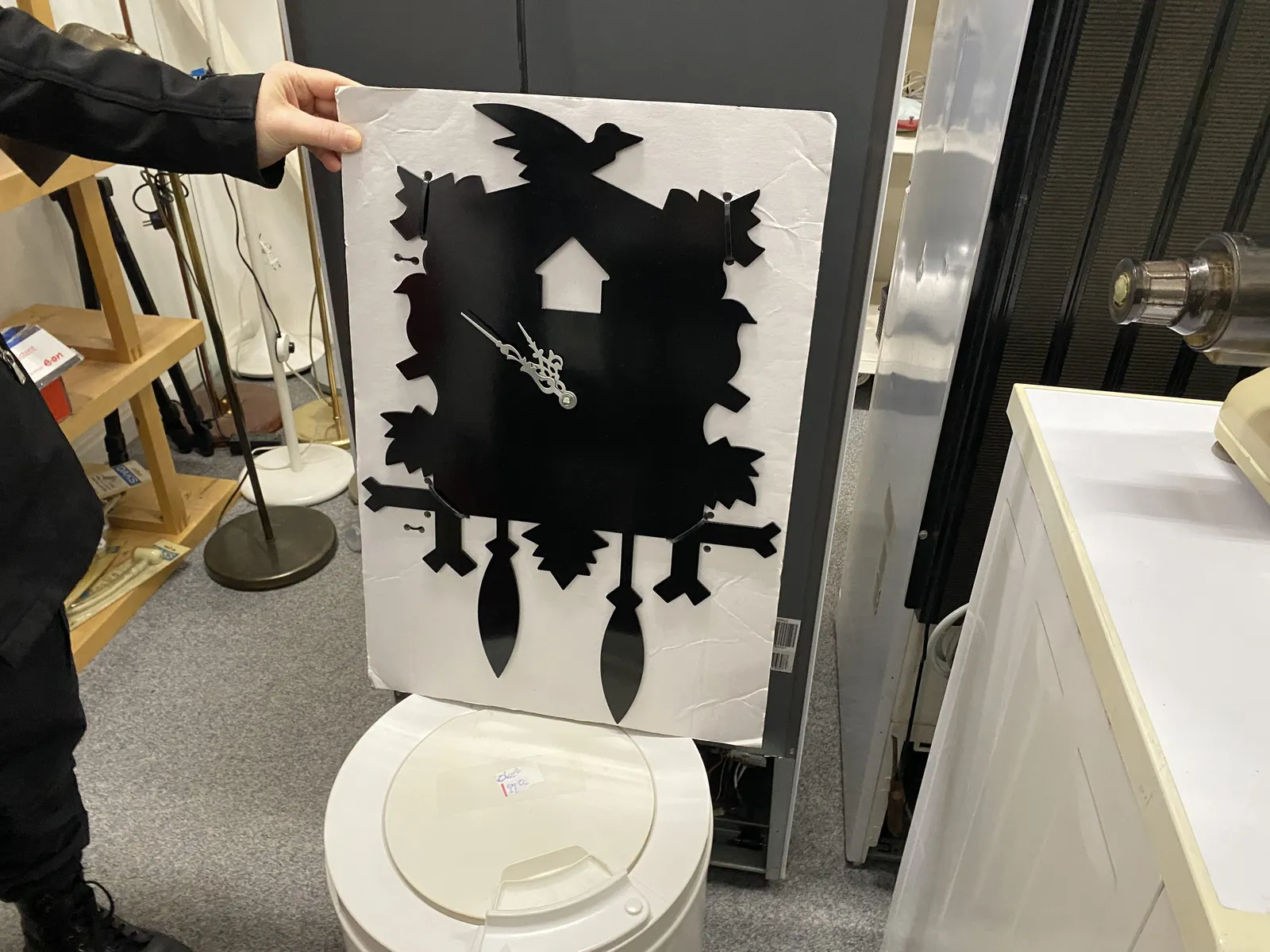 This cutout is shaped in the form of a cuckoo's clock. It seems to point at approximately 8 minutes to eleven.