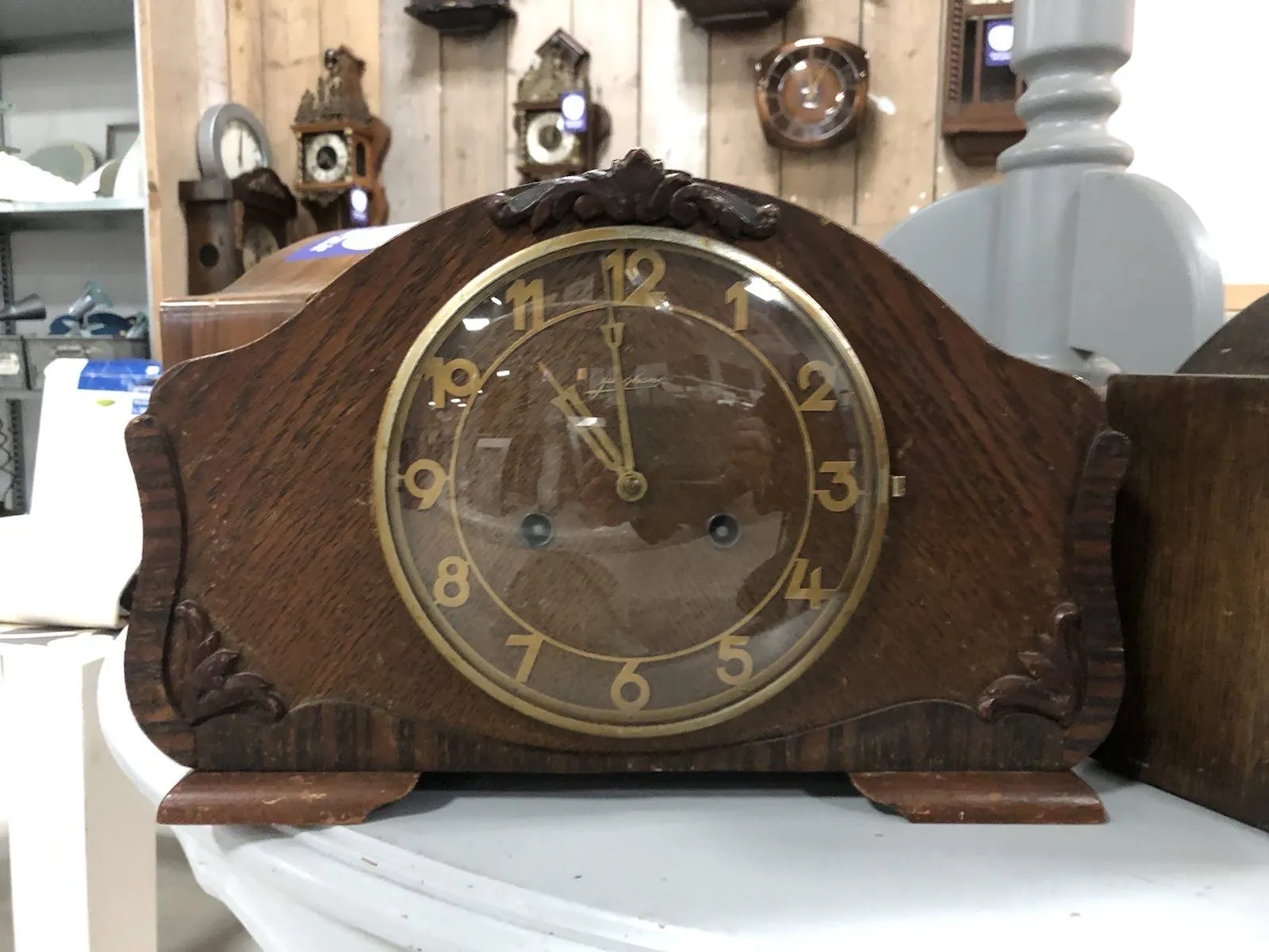 In the background are three cuckoo clocks, too blurry to see the time on them though. A wooden clock in the foreground points at 1 minute to 11.