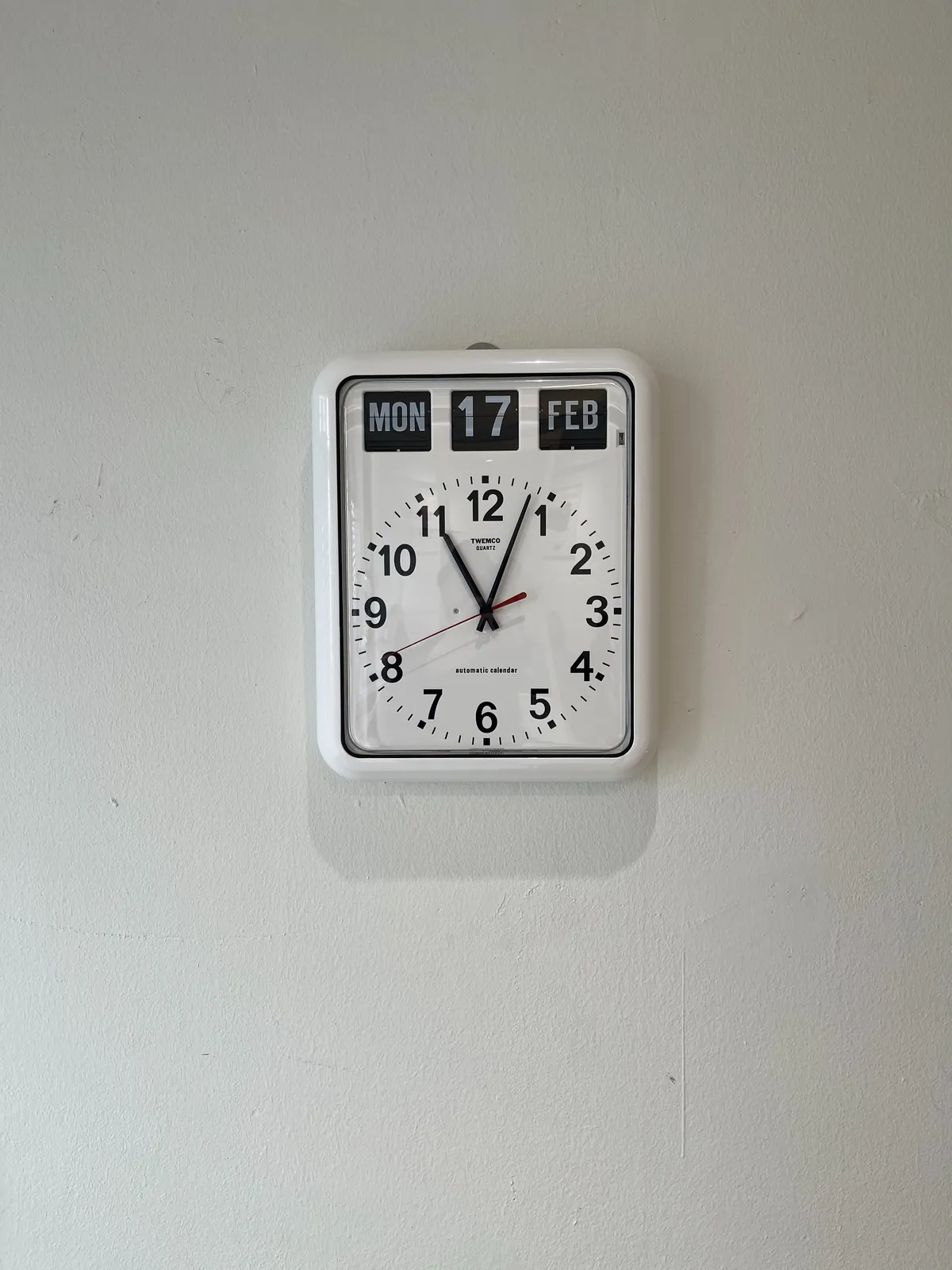 The flip calendar on this clock says it is Monday 17 February, which is probably not true. The clock itself points at 3 minutes past 11.
