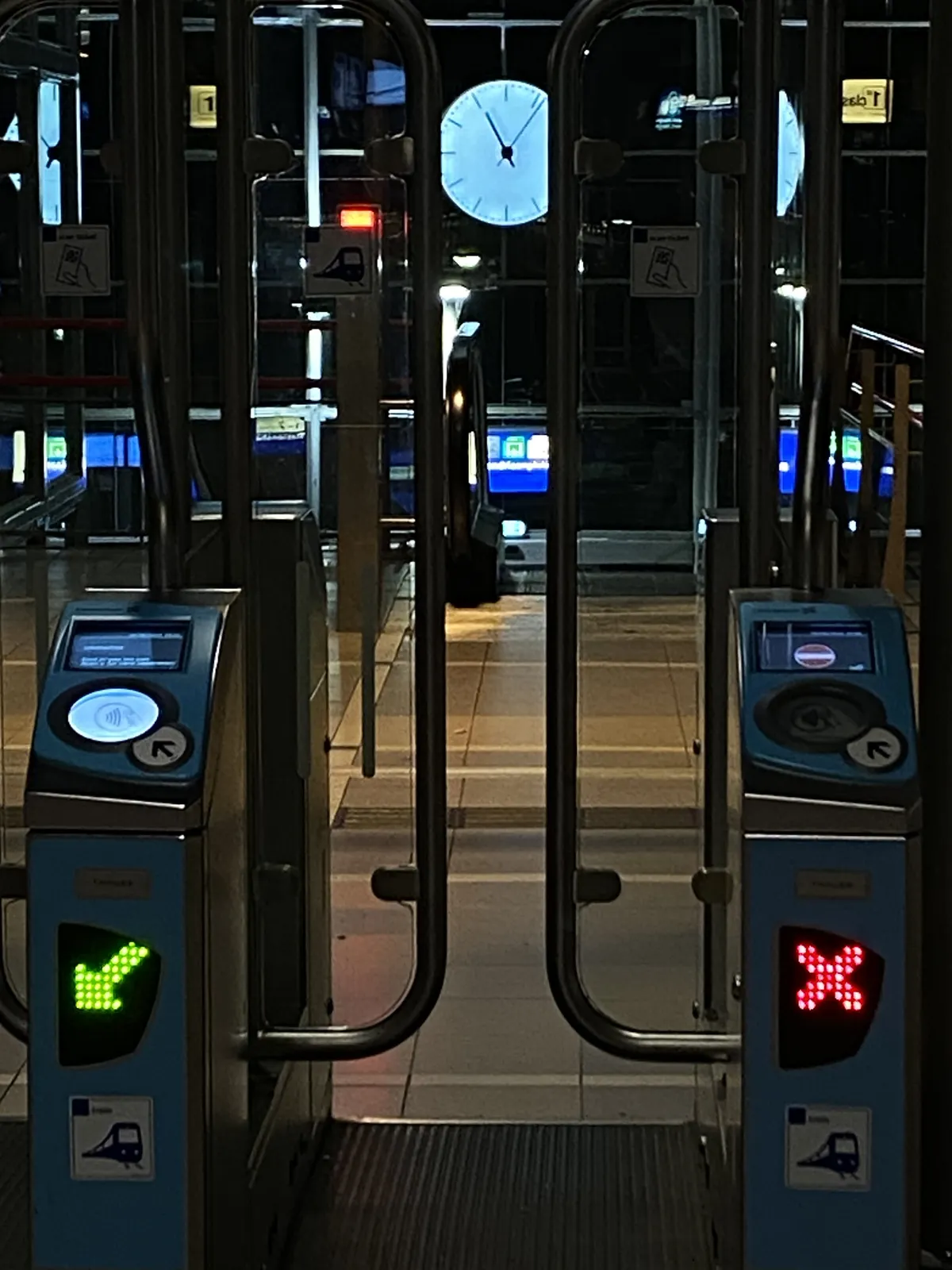 Between the doors of an entrance machine to the subway you can see a clock. It points at 6 past 11. 