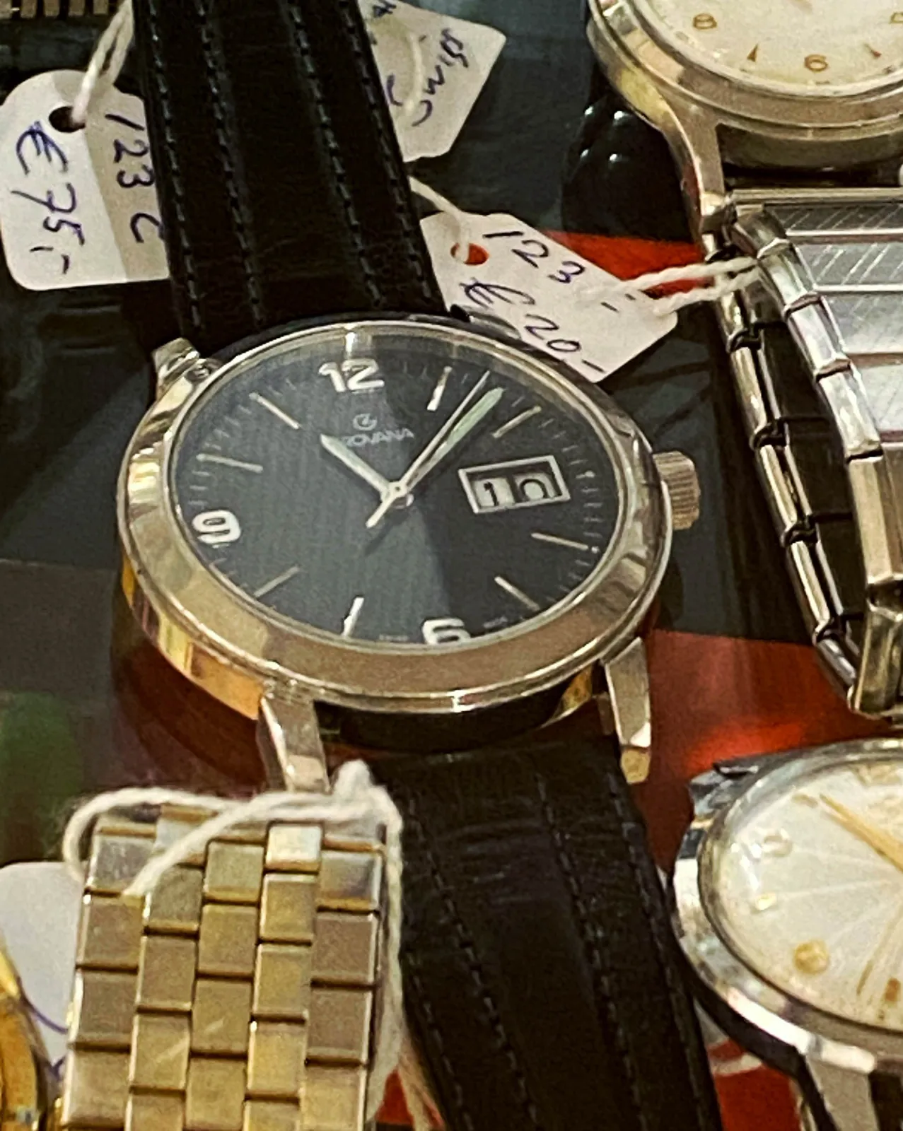 A few wrist watches. Most of them are in large part outside of the picture, so the time can only be seen on the one watch that positioned centrally in the composition. It points at 8 minutes past 11.