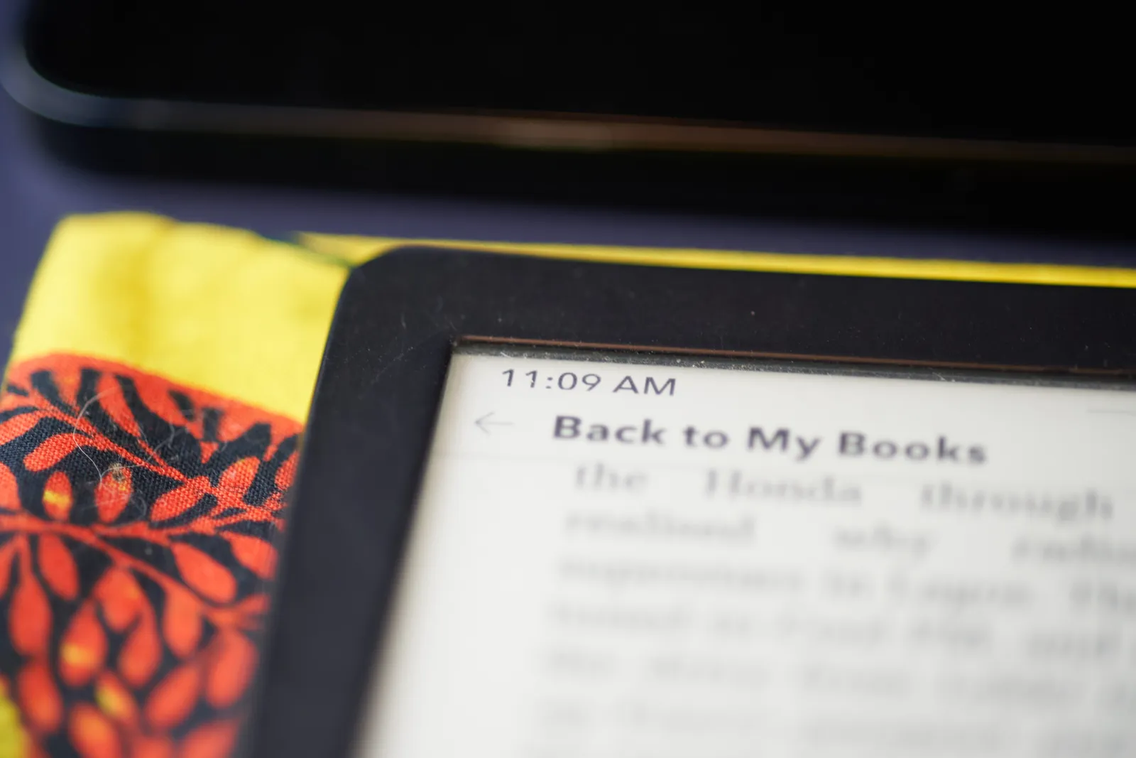 A picture of the corner of an ereader. There’s a digital clock that says it is 9 past 11.