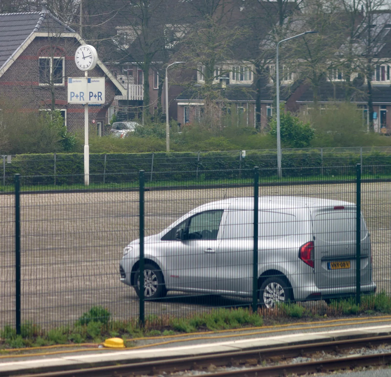 There’s a clock on this empty parking space, except for one car. On this clock it is 13 past 11.