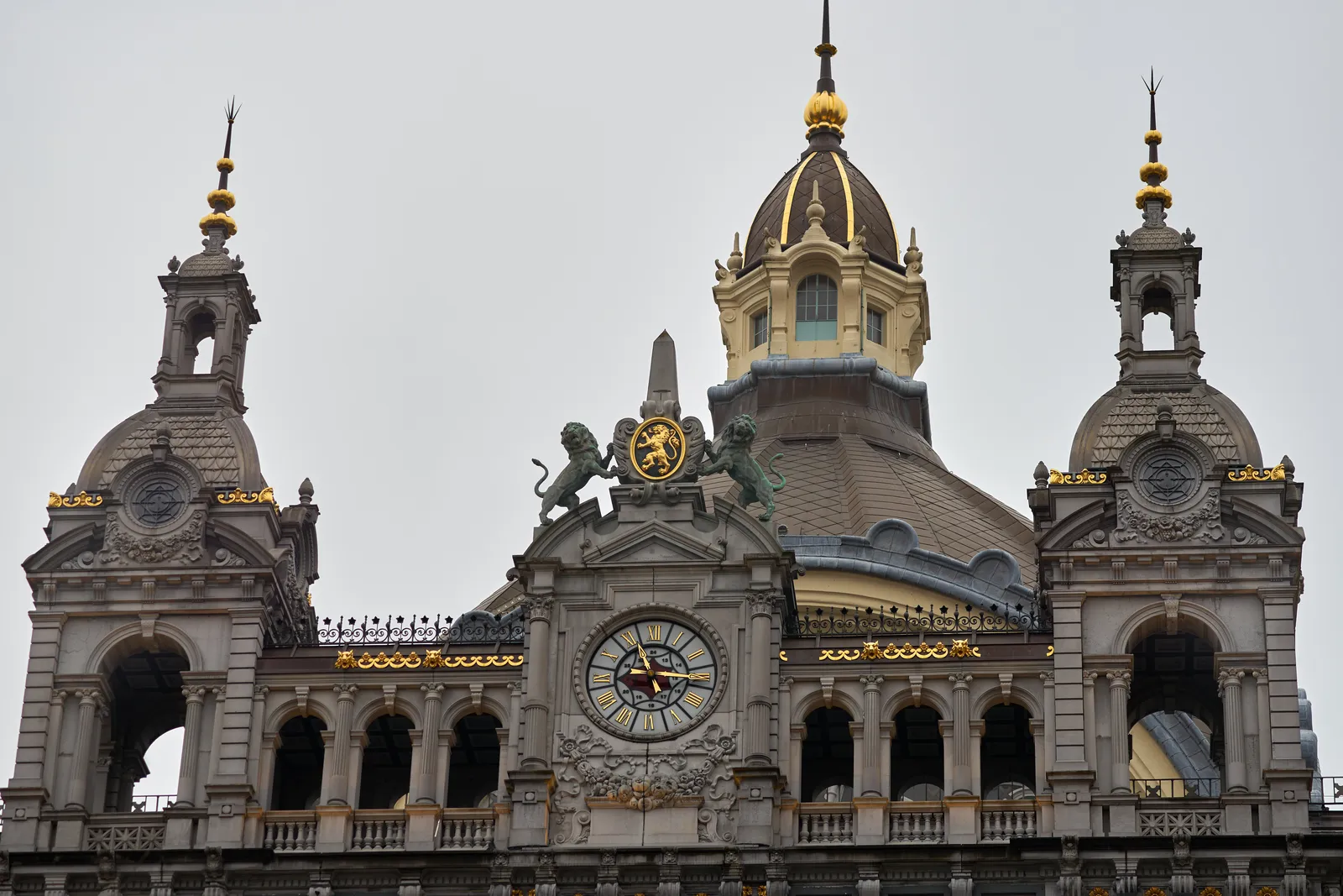 A golden clock on the roof of the Antwerp Central train station points at 16 past 11.