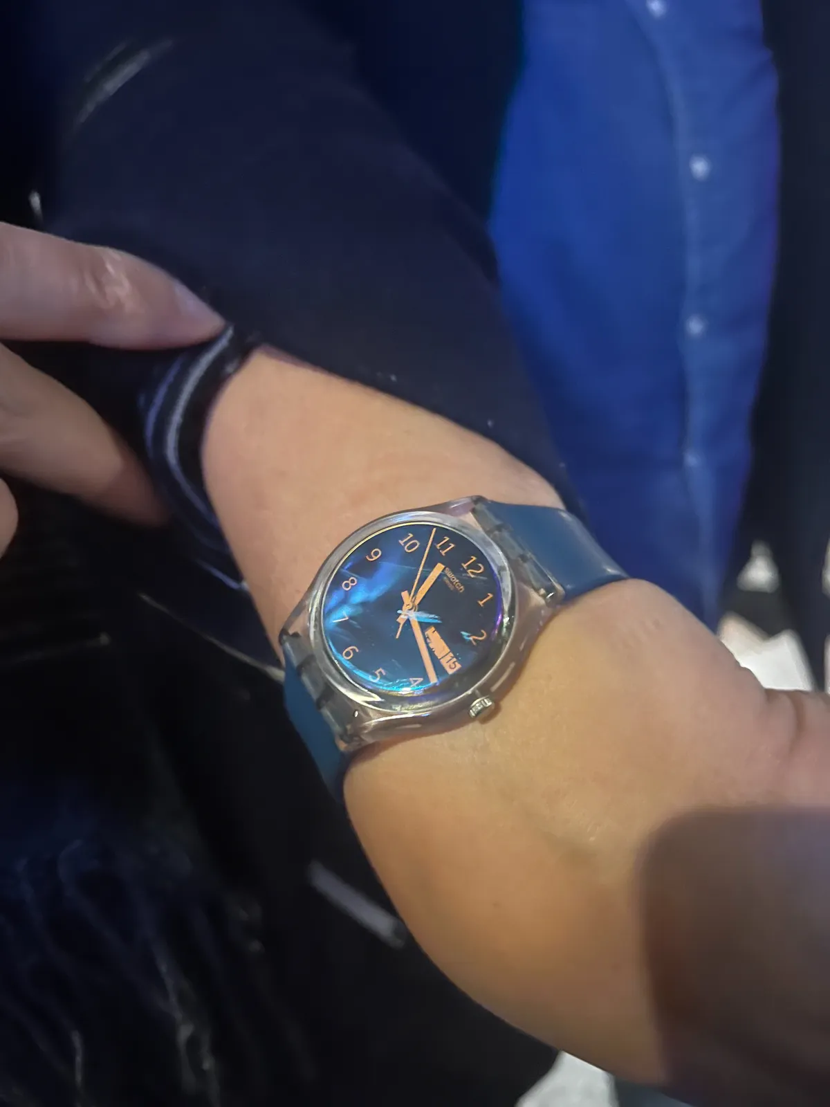 Someone rolls up their sleeve to show their wrist watch, It points at 16 past 11.