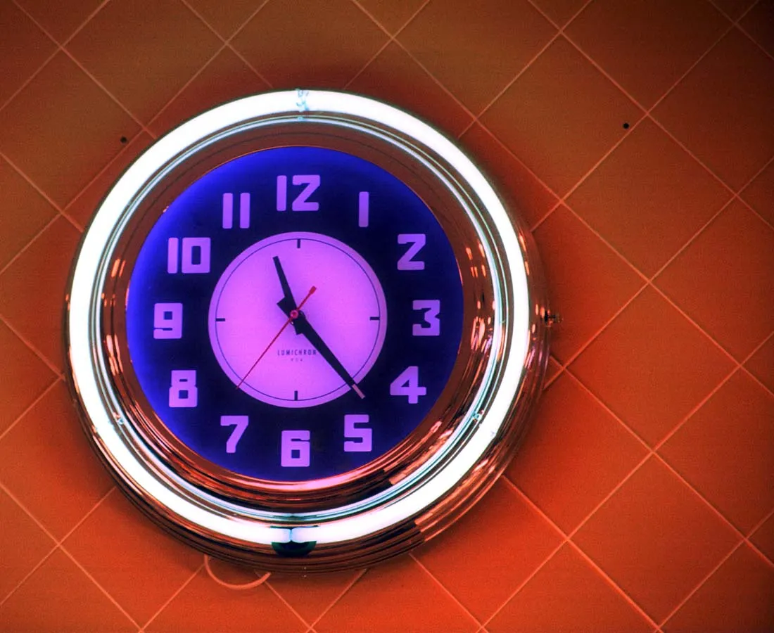 This shiny neon lit clock points at 11:22