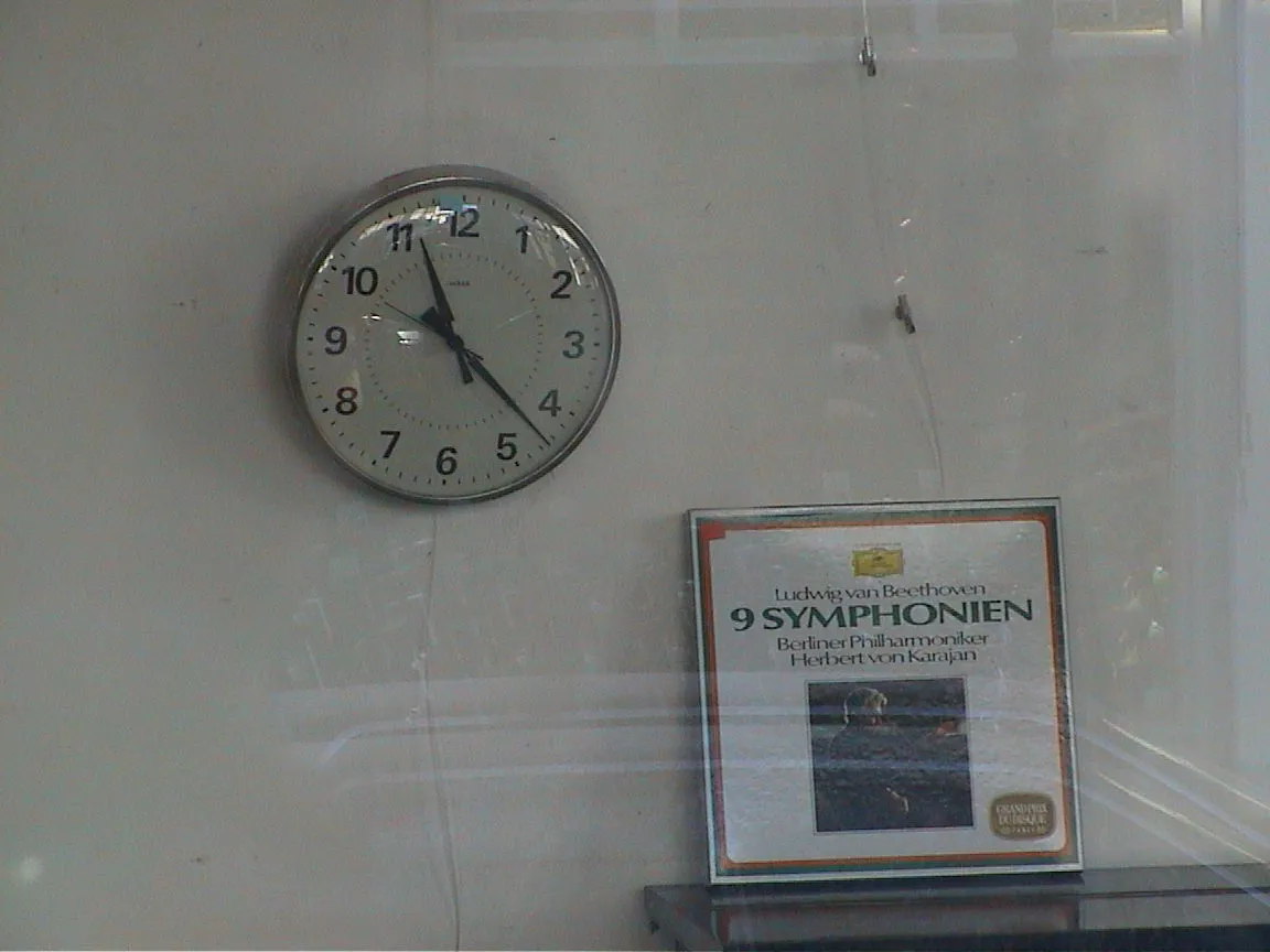 A record with the Ludwig van Beethoven’s 9 SYMPHONIEN by the Berliner Philharmoniker, lead by Herbert von Karajan stands next to a clock that points at 22 past 11.