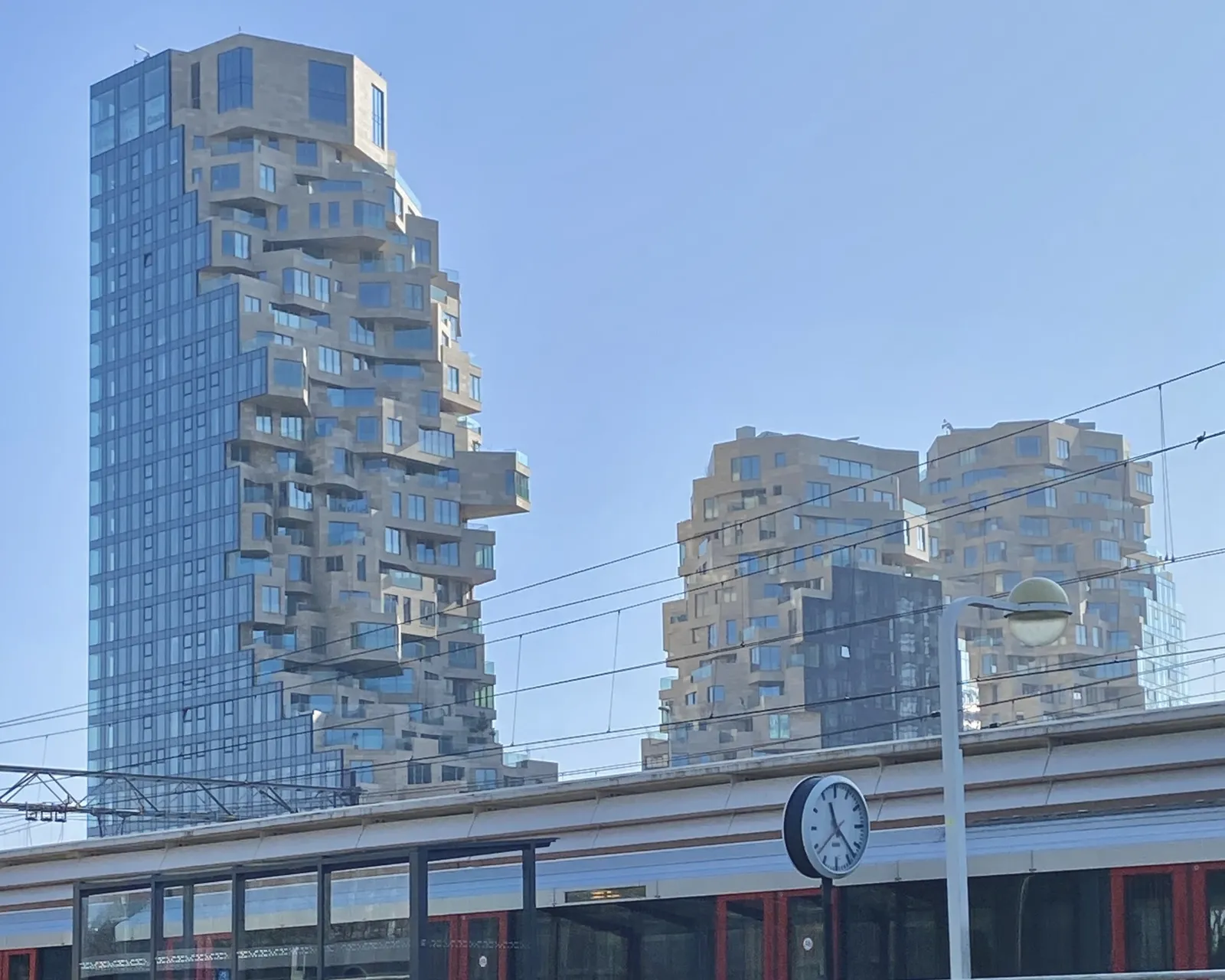 Three interesting, rather high appartment buildings ask for all the attention on this picture. But when you take the time to look around a bit you’ll see a clock that says it is 23 past 11.