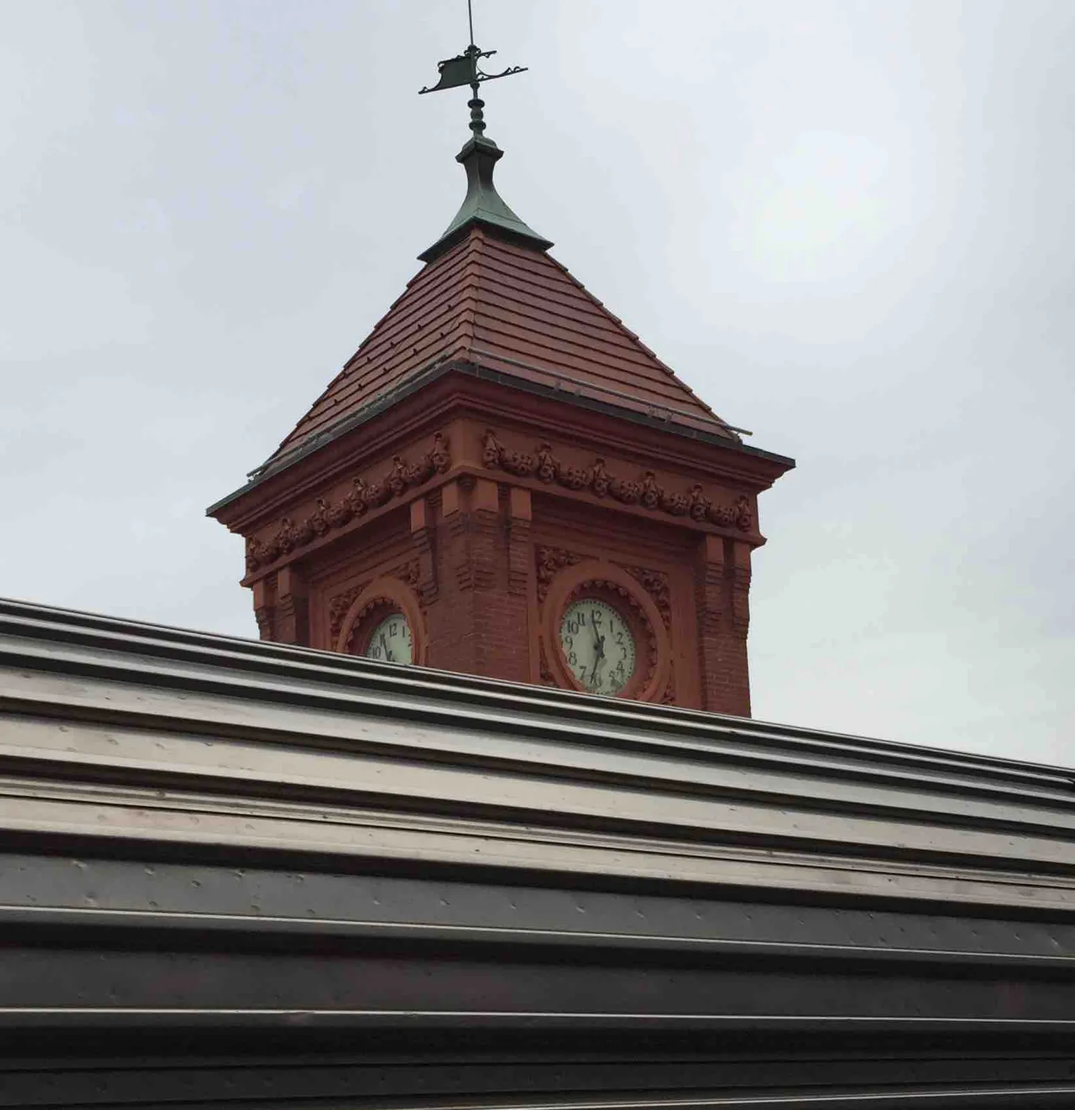 On this clock on a tower it is 33 past 11.