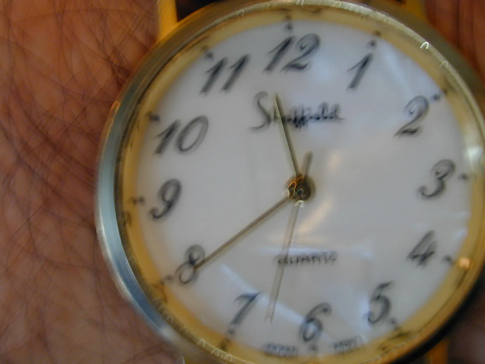 This blurry wrist watch points at 11:40