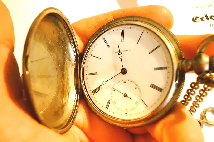 This shiny silver pocket watch points at 20 to 12.