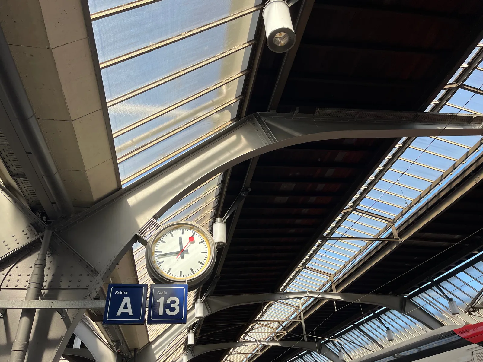 A clock in a train station on track 13, section A. It points at 17 minutes to 12.