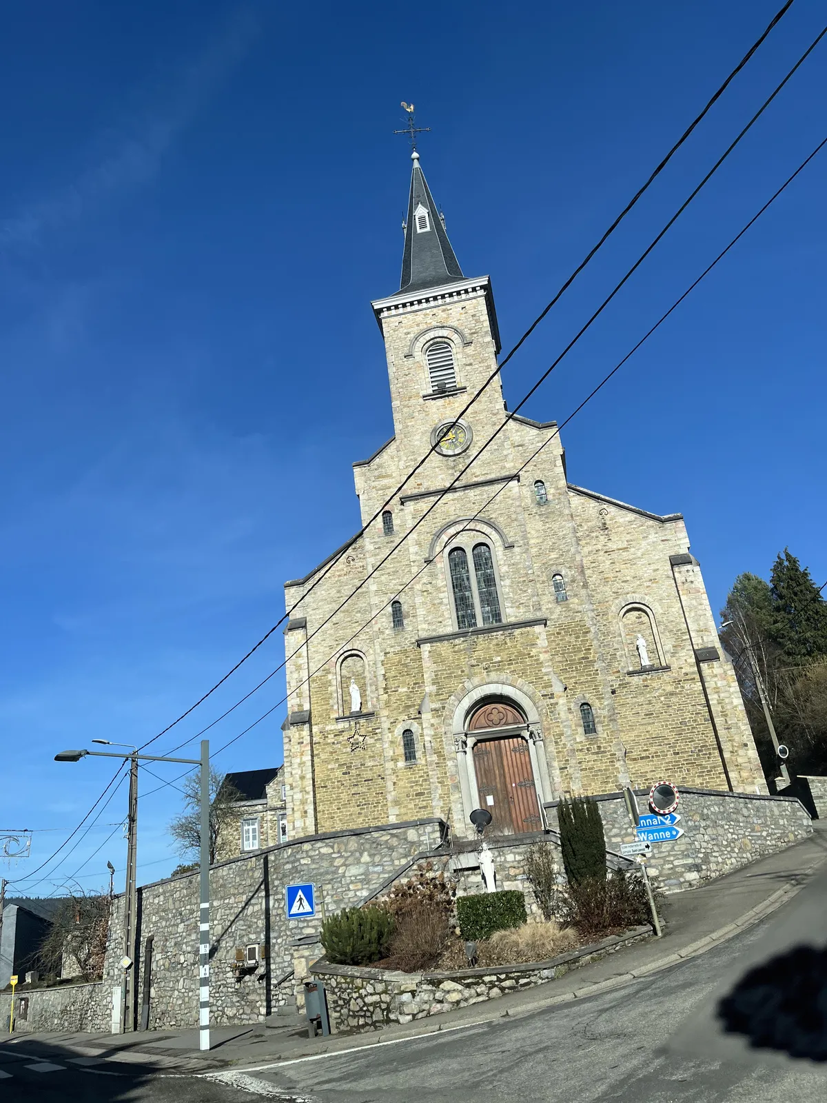 An old town’s church somewhere in the Ardennes. The clock on its tower points at 16 minutes to twelve.