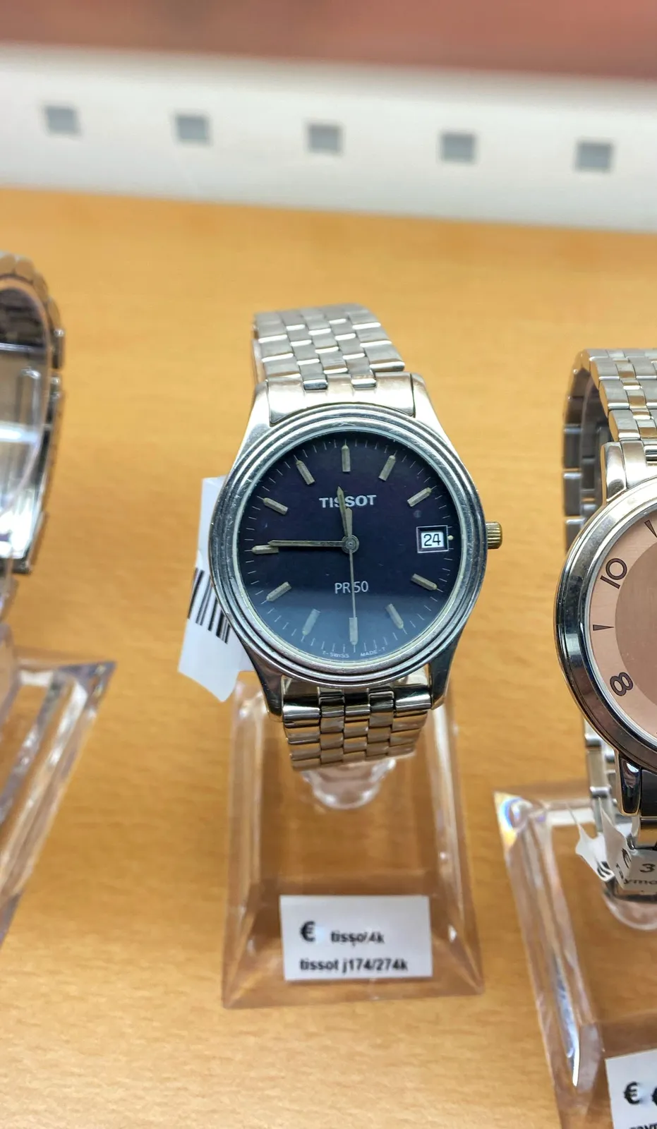 A simple wrist watch. It points at 14 minutes to 12.