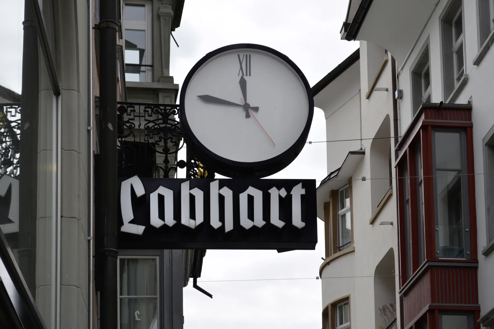 A clock outside of Labhart, a shop in St. Gallen says it is 11:47