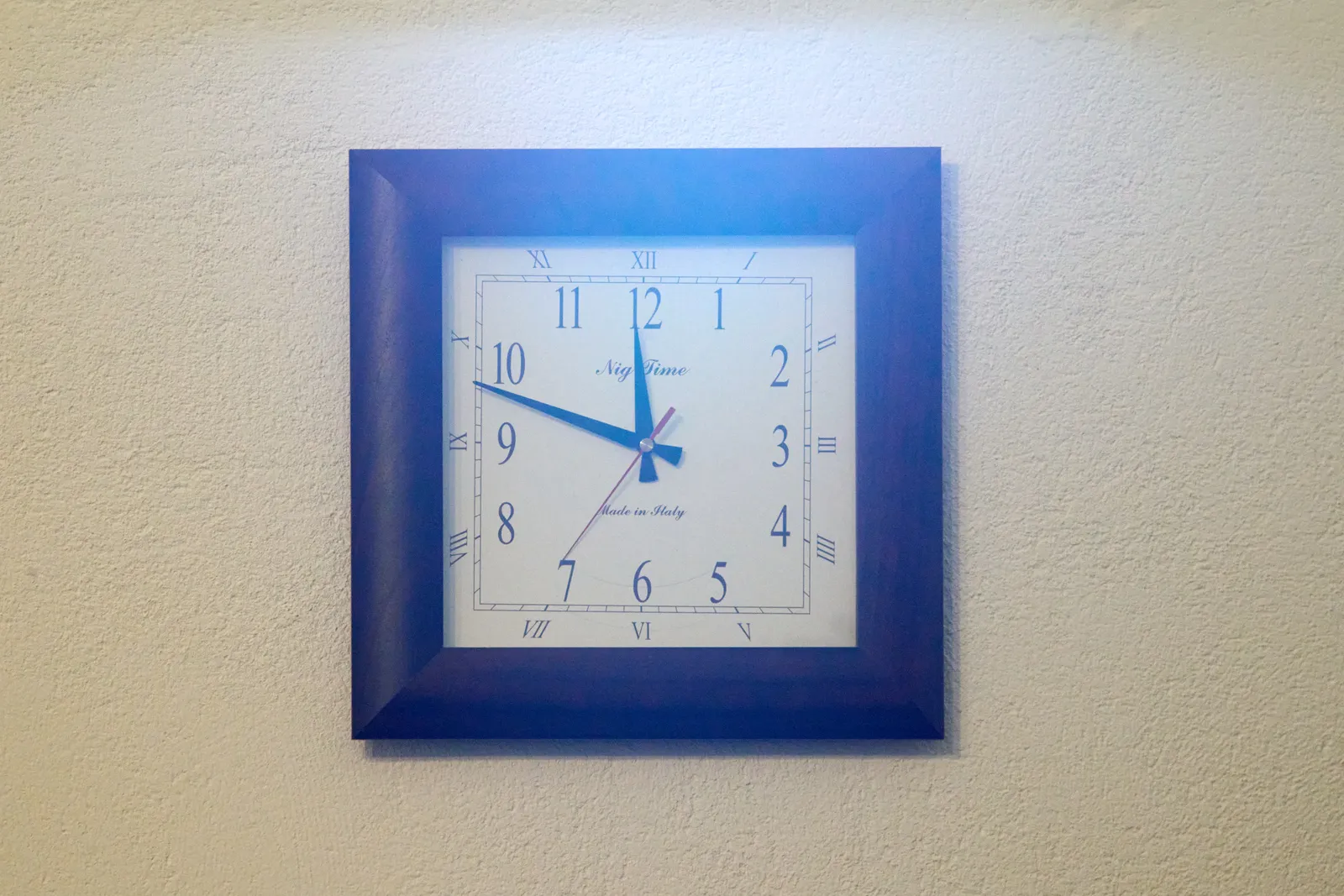A wall clock. It points at 12 minutes to 12.