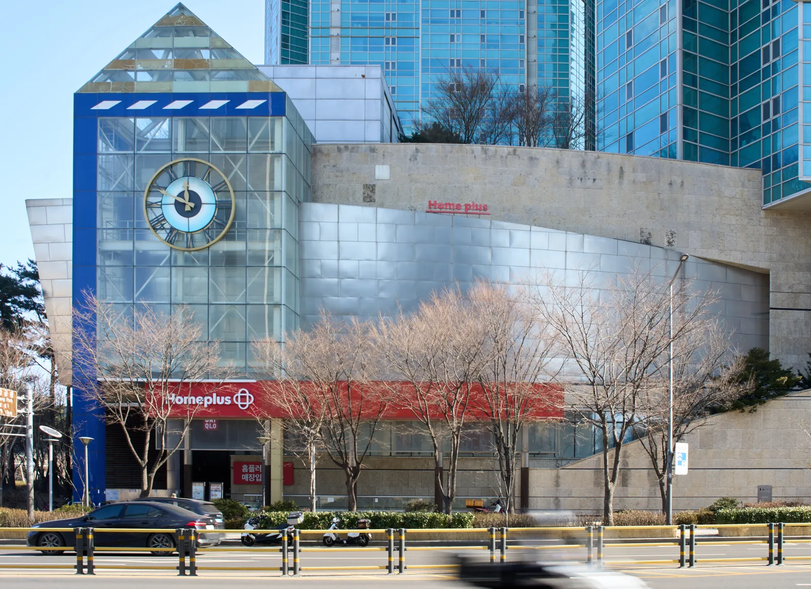 A modern building, or is it post modern? Curves, rectangles and triangles, and a circle that makes a clock. It points at 11 minutes to 12.
