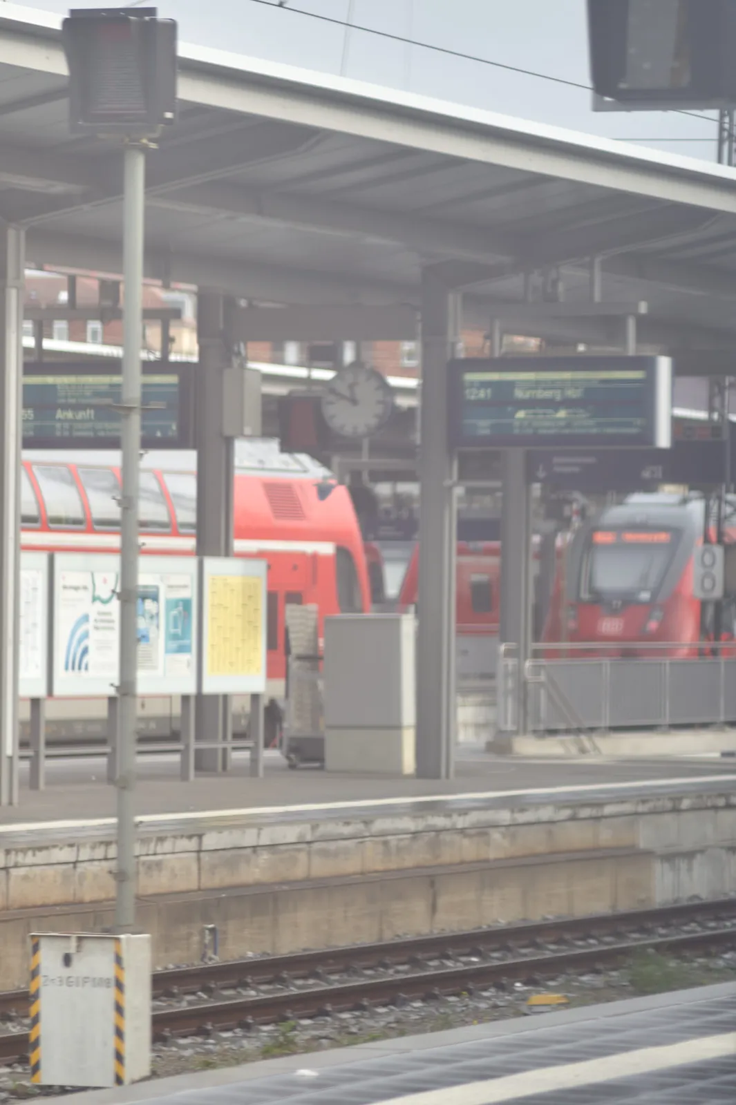 In the distance, a bit blurry, a clock on a train station. It points at 11 minutes to 5.