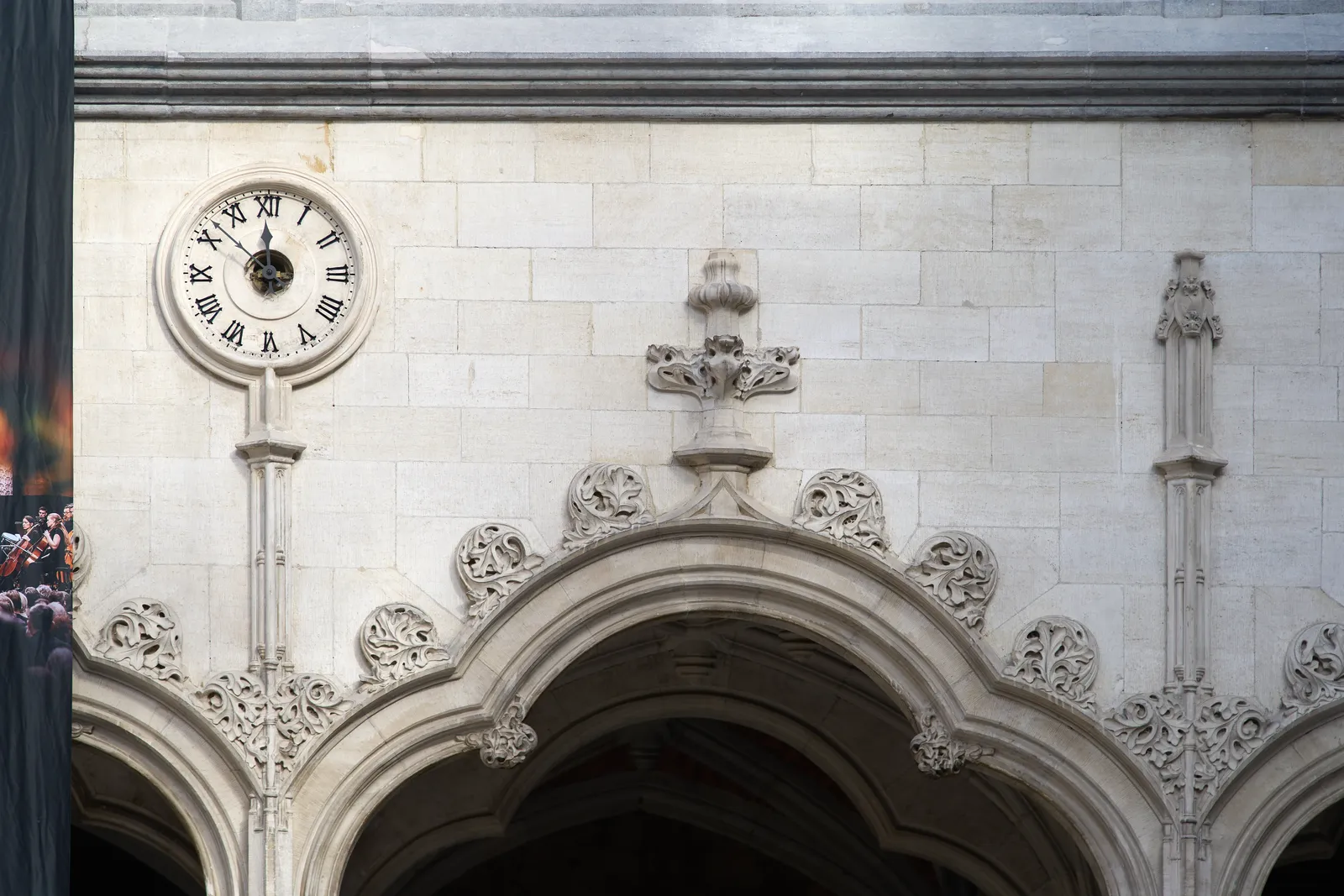 Some neoclassical ornaments with a clock, which points at 8 minutes to twelve.