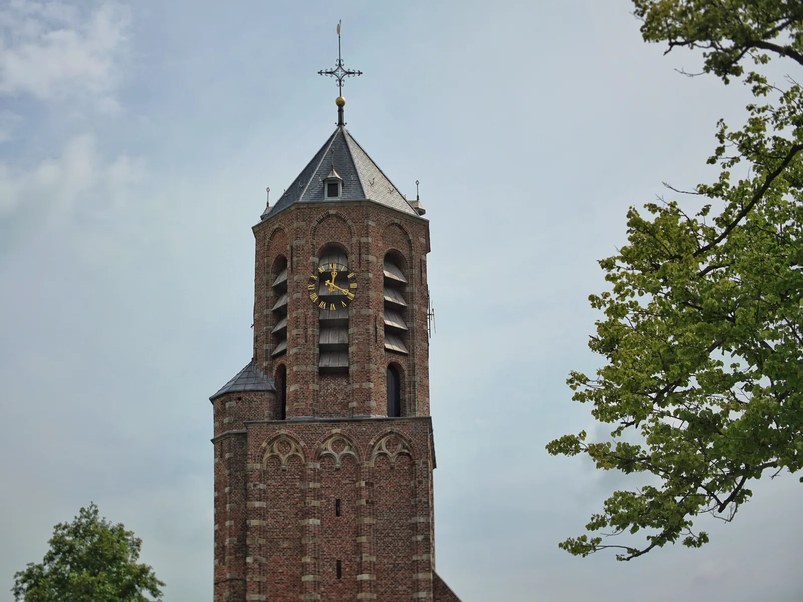 A strange asymmetrical, eight sided church tower with clocks. On the clock that’s facing us it is 19 past 12.