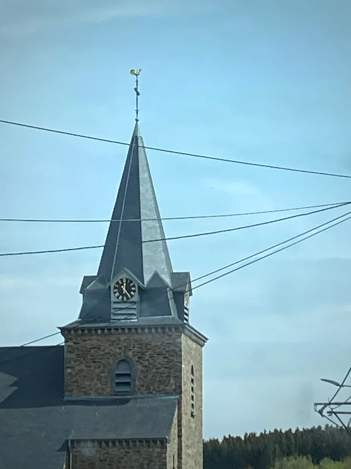 A church with a clock. It points at 25 minutes past 12.