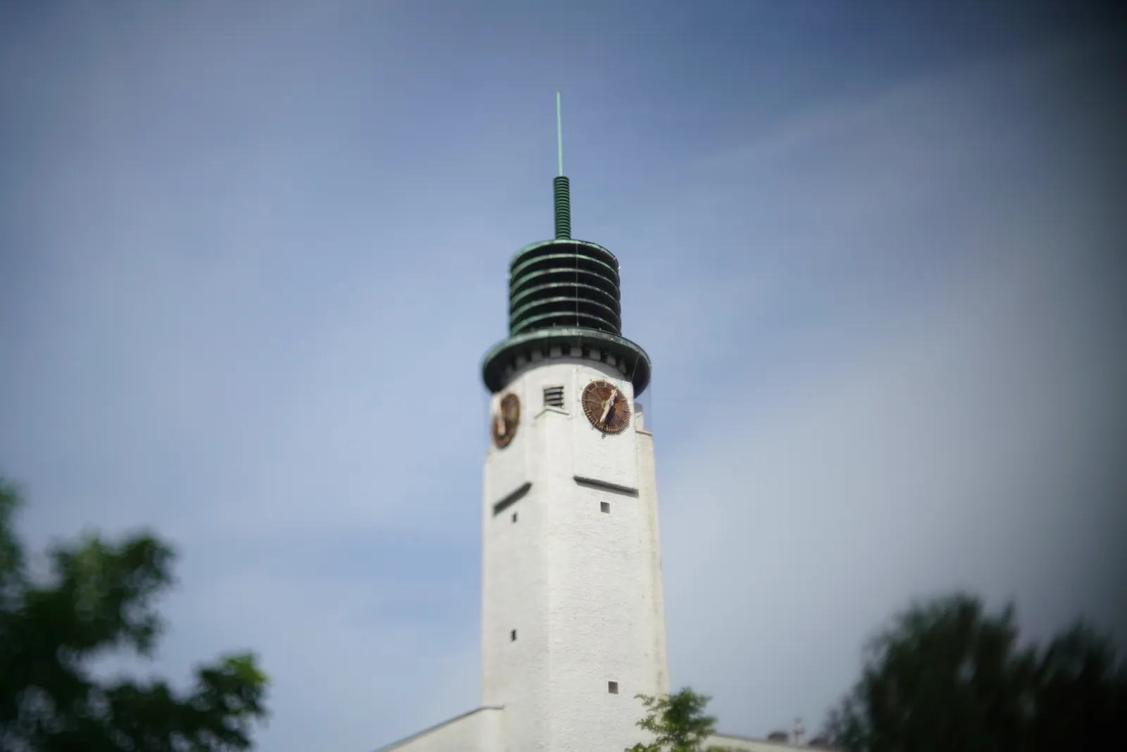 On an building in Betondorp in Amsterdam there’s a tower with clocks. Most of the picture is blurry, except for one of the clocks. It points at 33 past 12. 