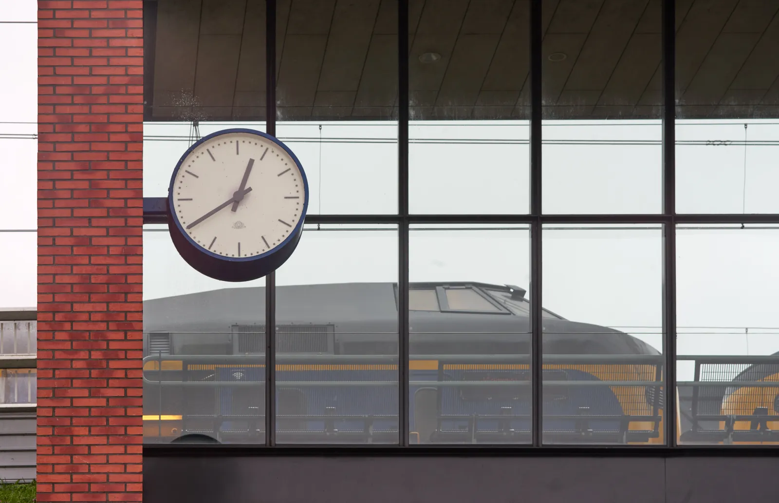 A large clock at a train station points at 40 past 12.
