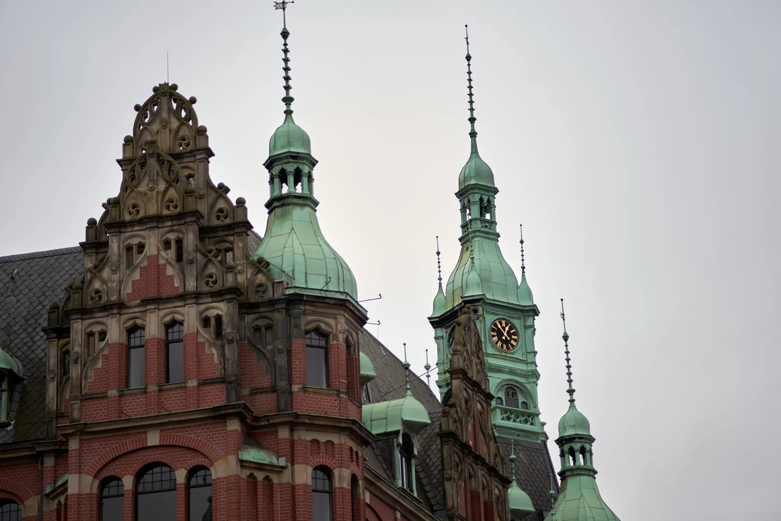 Brass domes on a frivolously ornamented building. There’s a clock on one of the domes which indicates that it is 6 minutes to one.