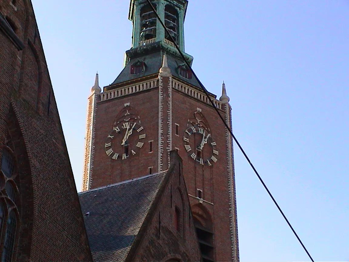 You can see two clocks on two sides of this church tower. Their arms point at one minute past one.