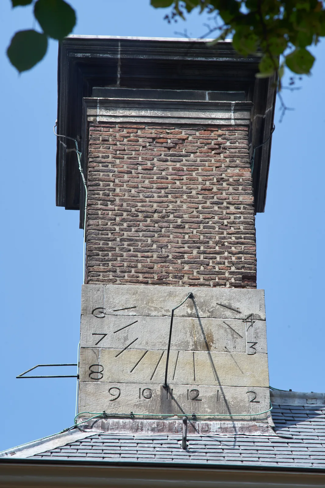 A south facing sundial attached to a chimney in Leiden. It points at approximately four minutes past one.