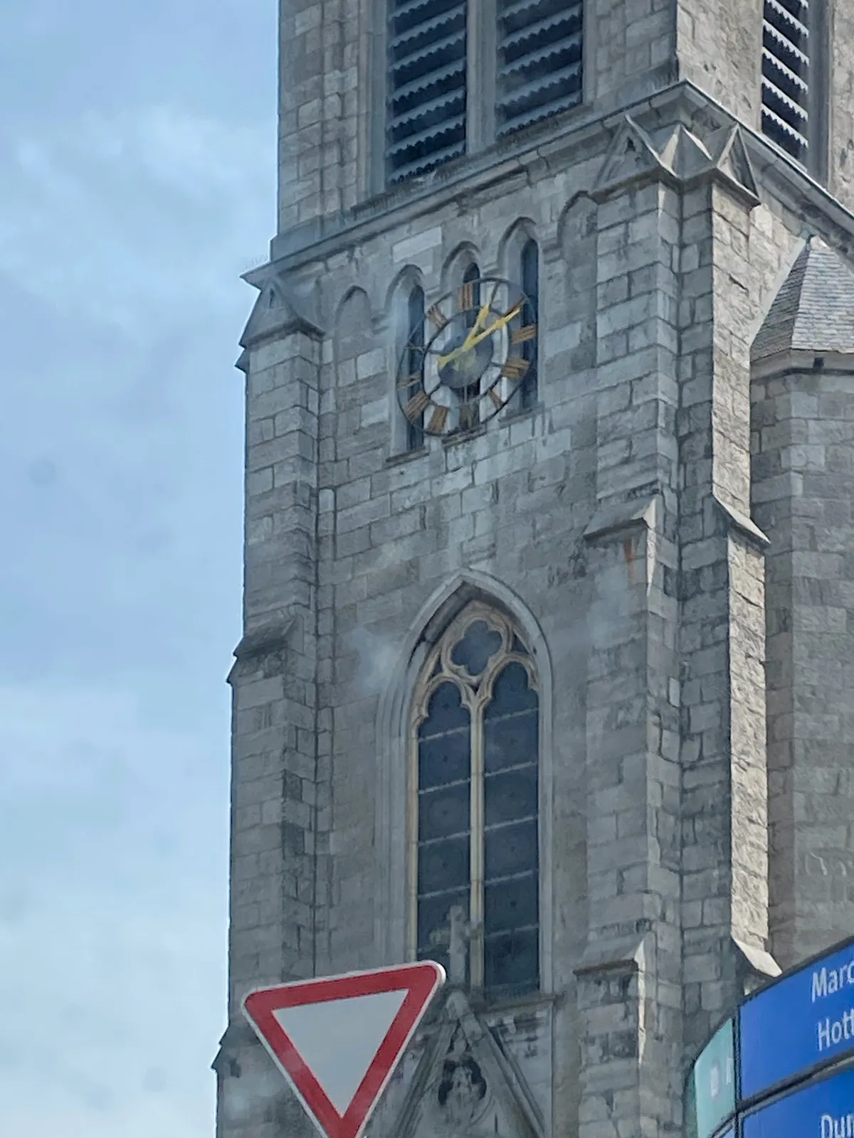 Just part of this church can be seen. There’s a clock on it that points at 10 past one. 