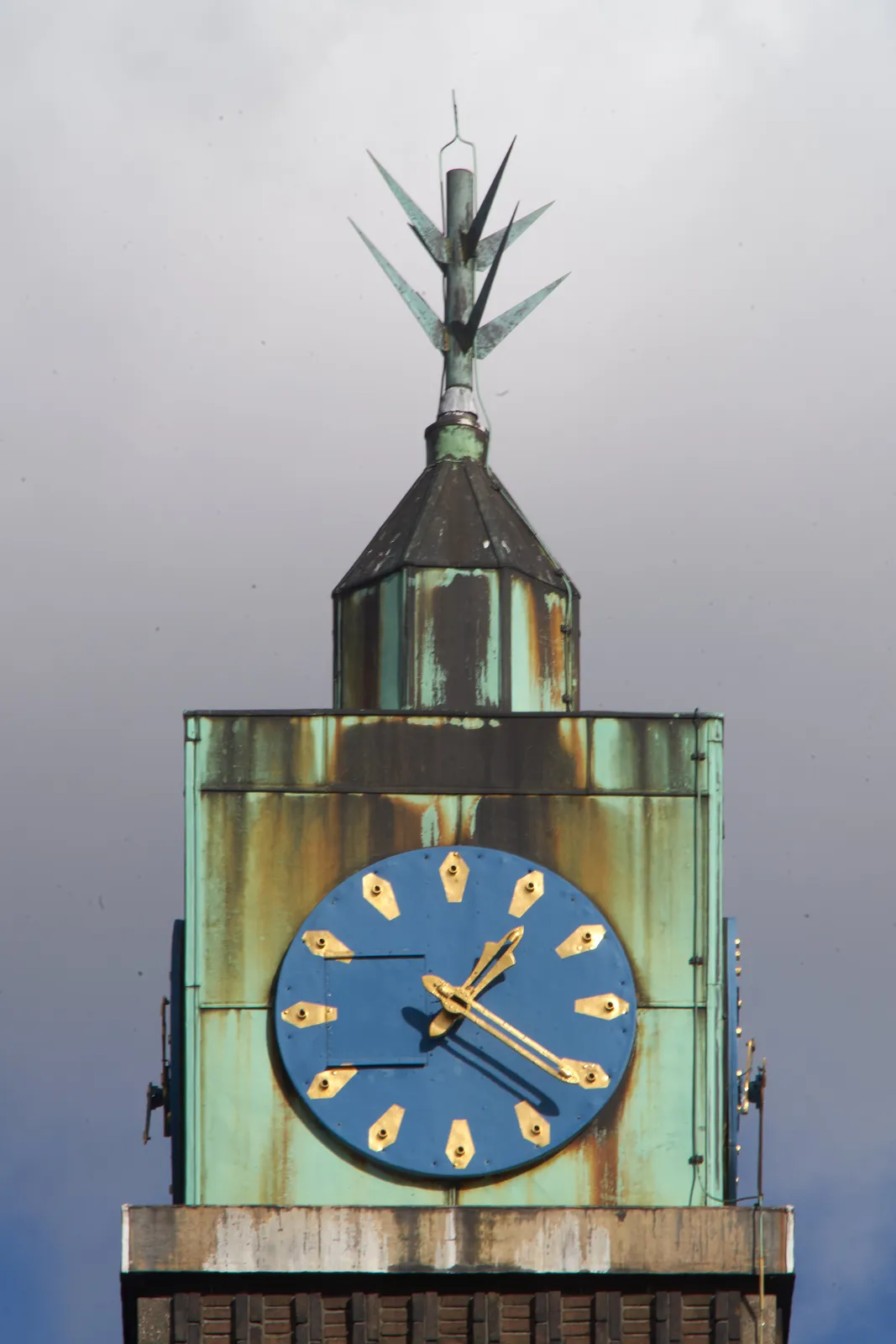 A clock on a poity church tower points at 21 past one.
