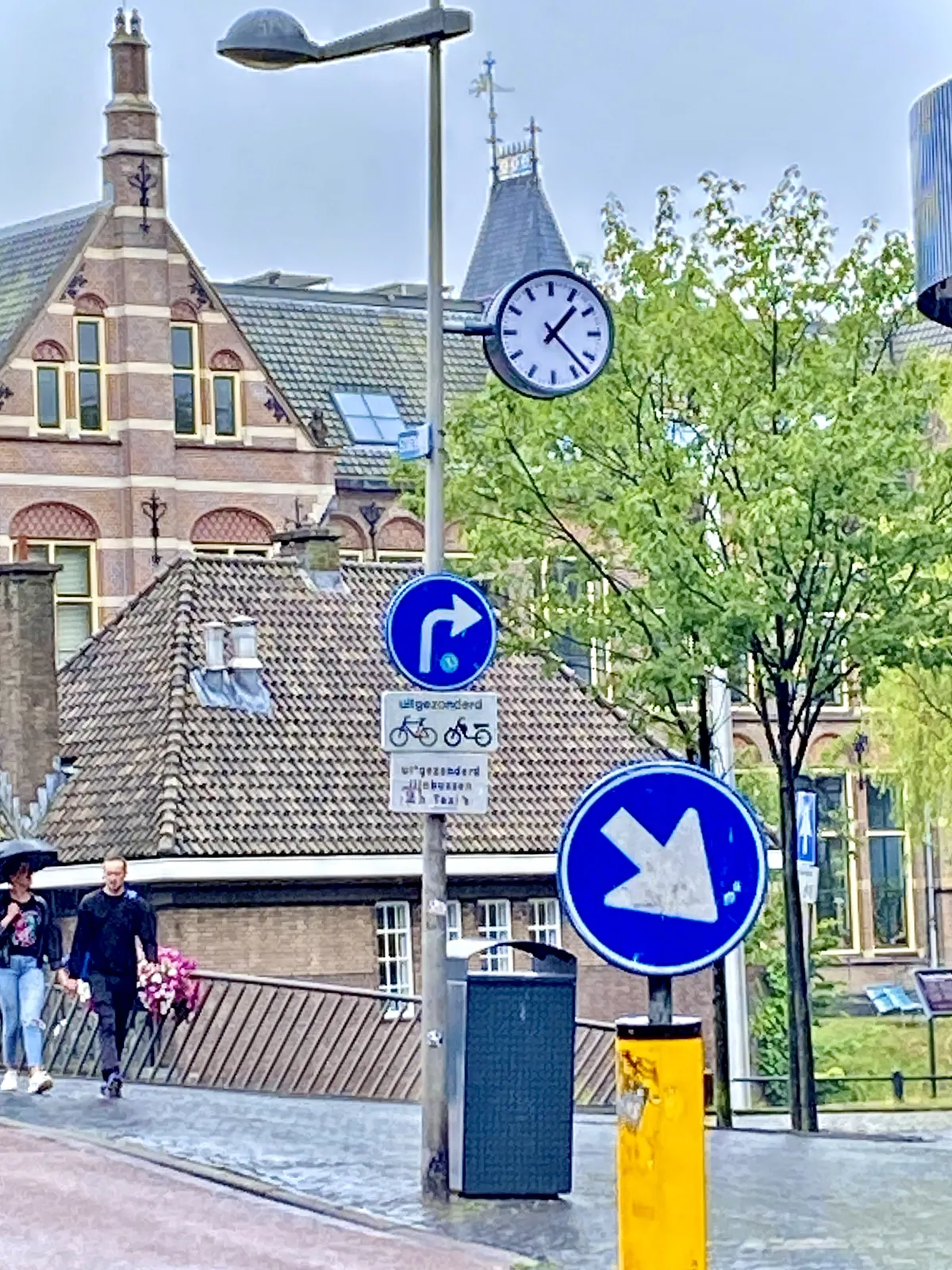 A clock in rainy Leiden. It points at 23 past one.