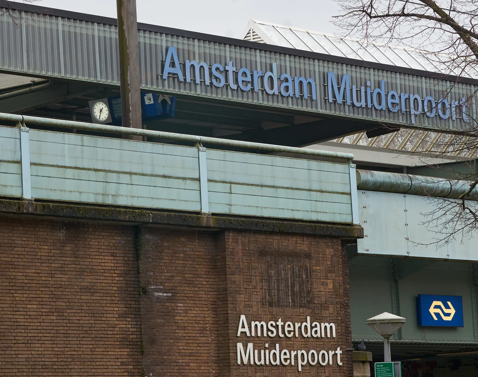 It says in very large letters Amsterdam Muiderpoort on the wall, and on the roof of this station. A clock can be seen which says it is 34 past one.