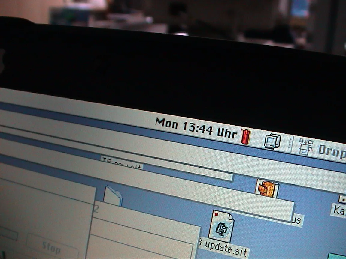 The clock on a very old German Mac system (by the looks of it it’s pre MacOS, Classic OS 9 maybe?) says it is 13:44 Uhr.