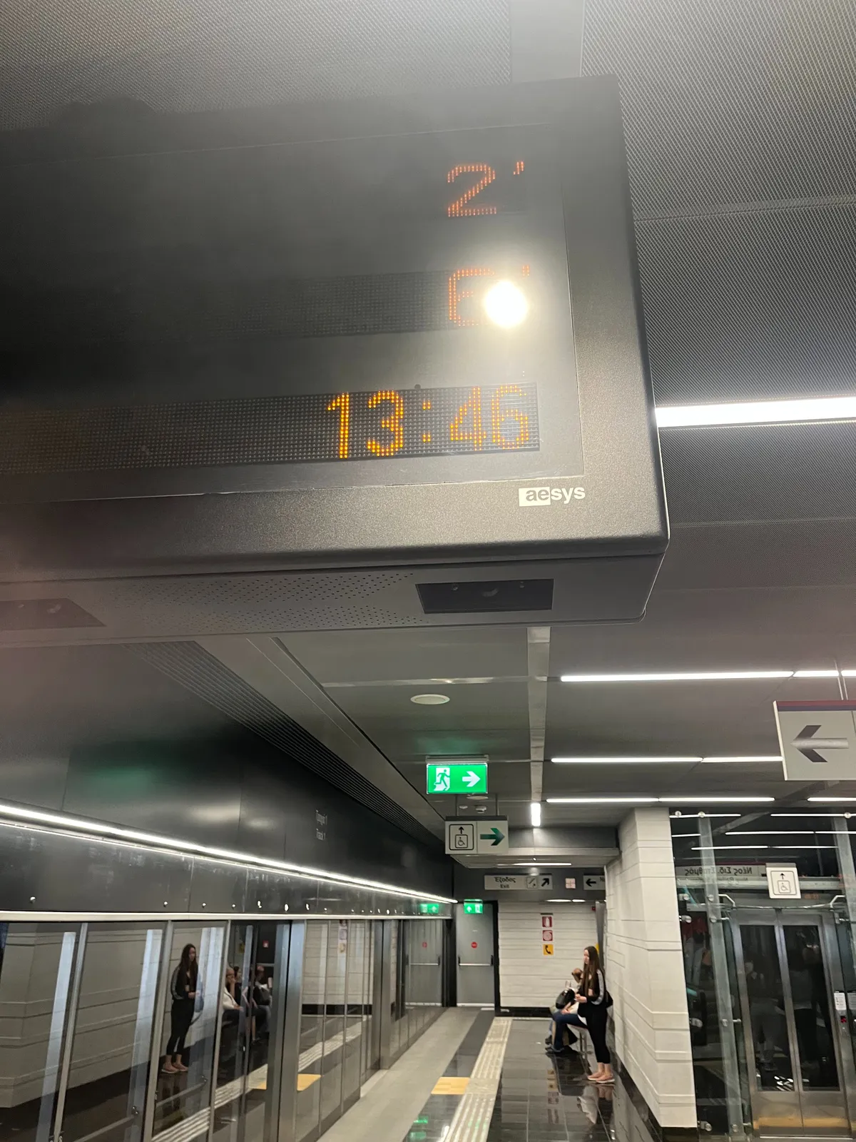 A display in a metro station displays the time as 13:46