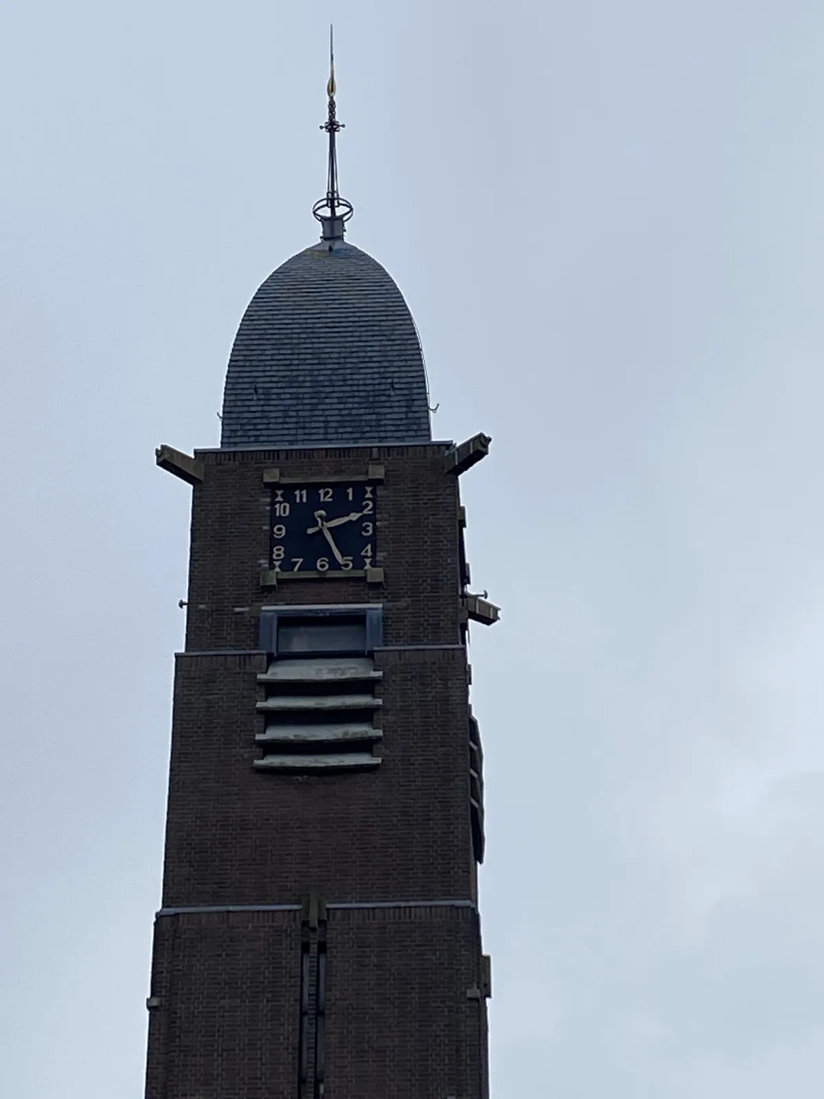 A tower with a clock on it. It points at 26 minutes past 2.