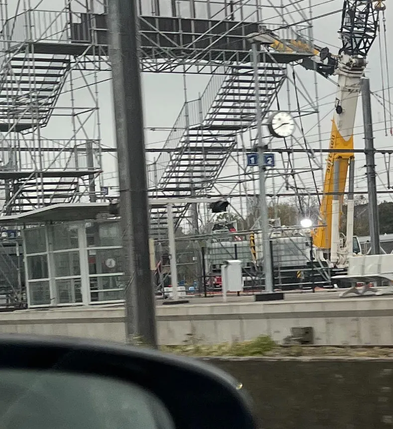 Lots of scaffolding, stairs, poles, and wires. There’s also an enormous crane. And there’s a clock on a pole which points at 20 to 3.