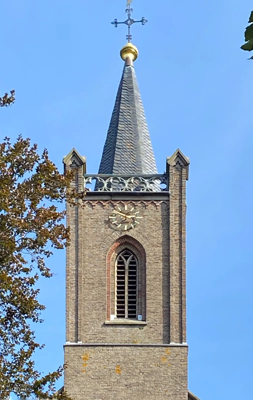 A rather simple brick church tower, like many church towers in the Netherlands. The clock on this tower points at 9 minutes to 3.