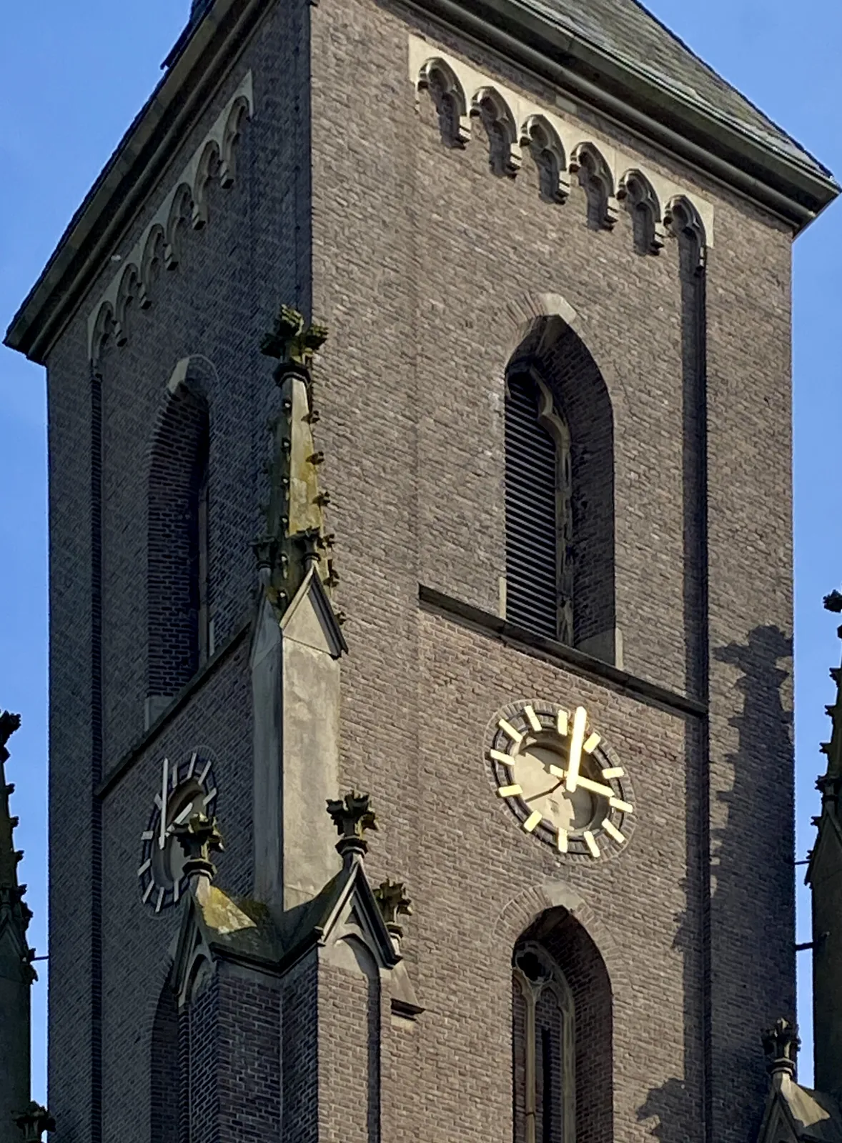 A rather simple brick church tower, like many church towers in the Netherlands. Maybe just slightly more ornamented. The clock on this tower points at 2 minutes past 3.