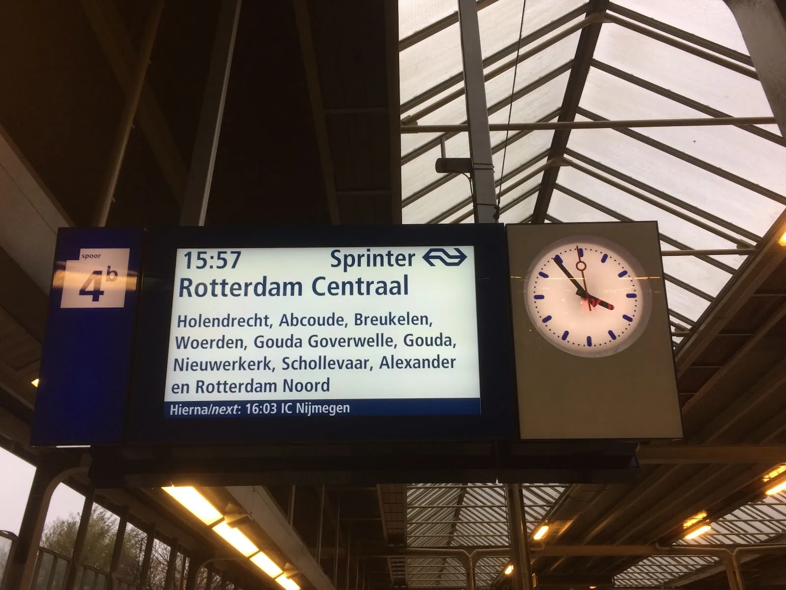 The train to Rotterdam will leave at 15:57. Three more minutes to wait, according to the clock.