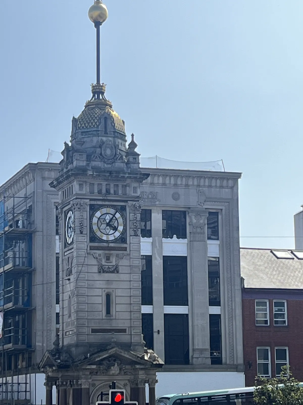 Some sort of a monument, in the shape of a tower with a clock on it. It points at five past four.
