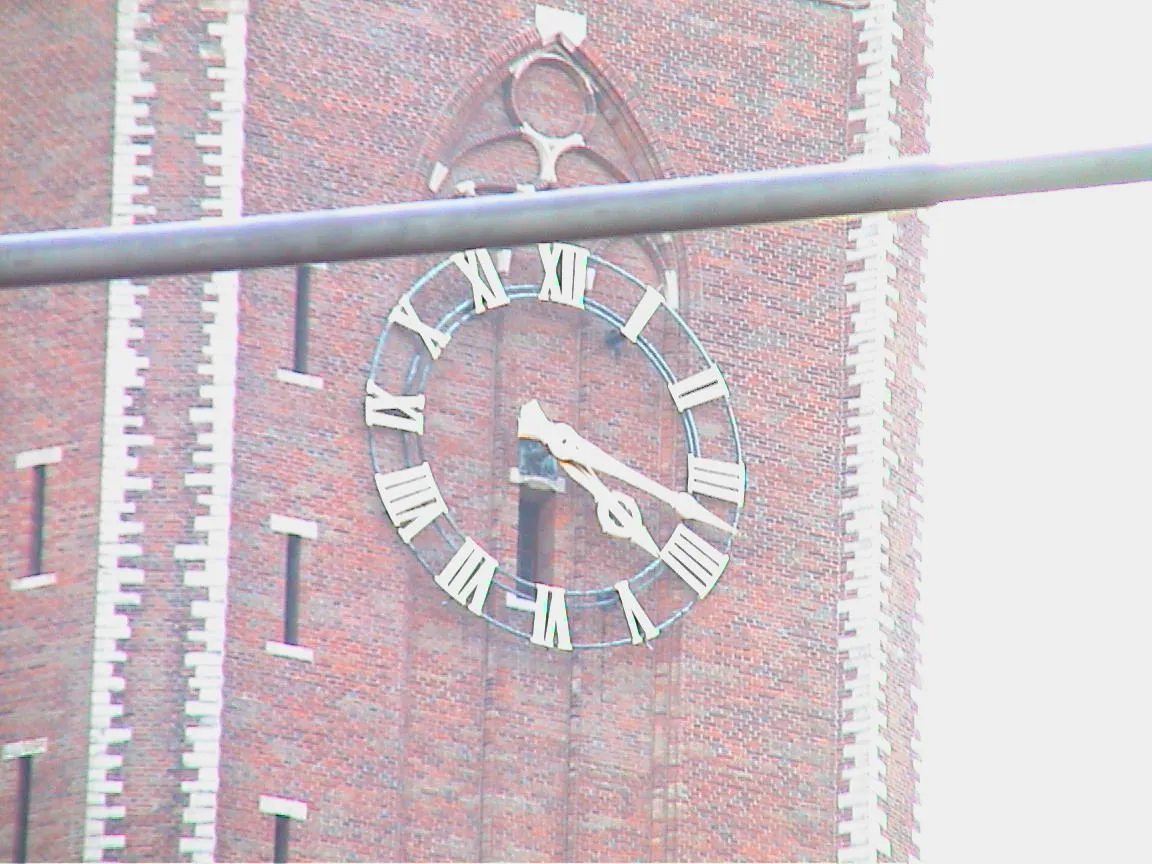 A clock on a church tower points at 17 past four.