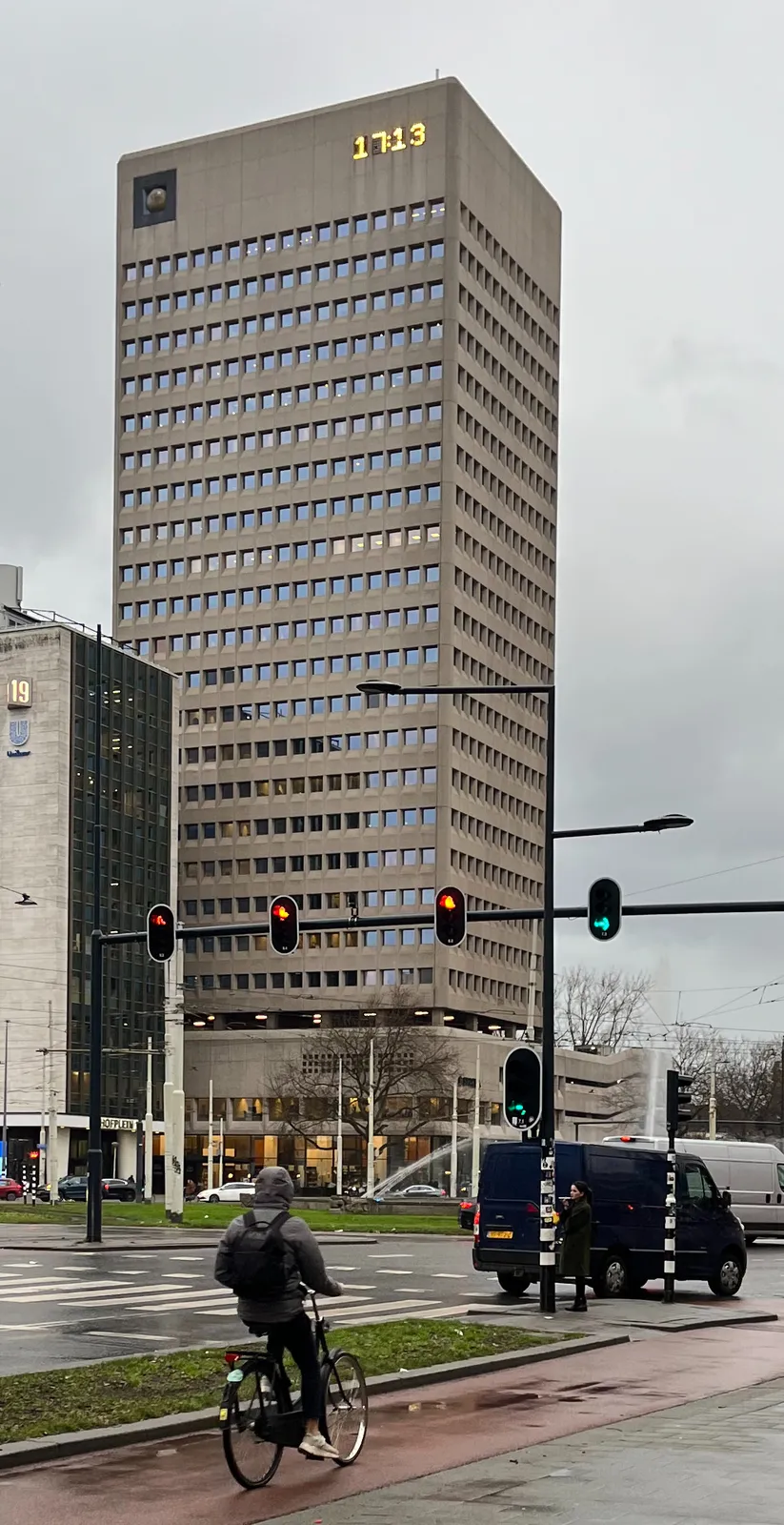 An enormous, high brutalist building. There’s a huge stone ball built into the wall, near the roof. And there’s a huge digital clock built into the wall near the roof as well. It displays the time as 17:13.