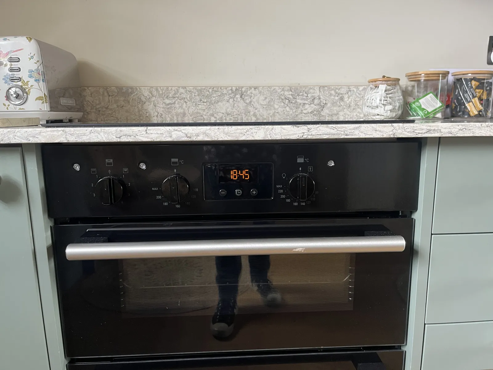 The digital display on a stove shows that it is 18:45