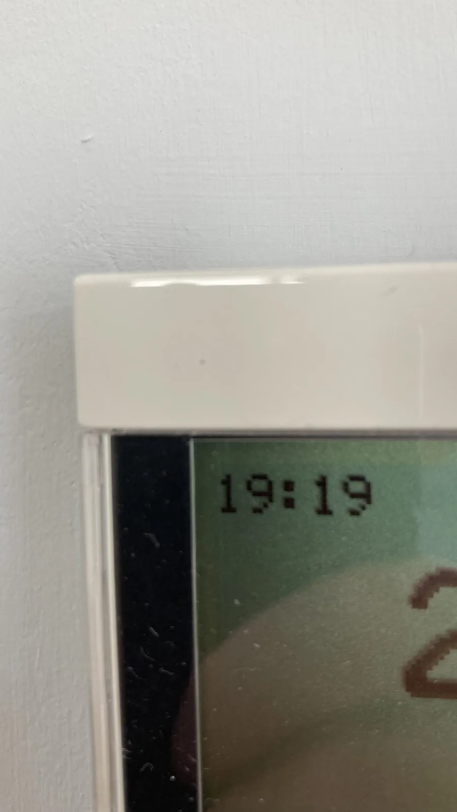 A close-up of the corner of a digital display. Is says the time is 19:19.