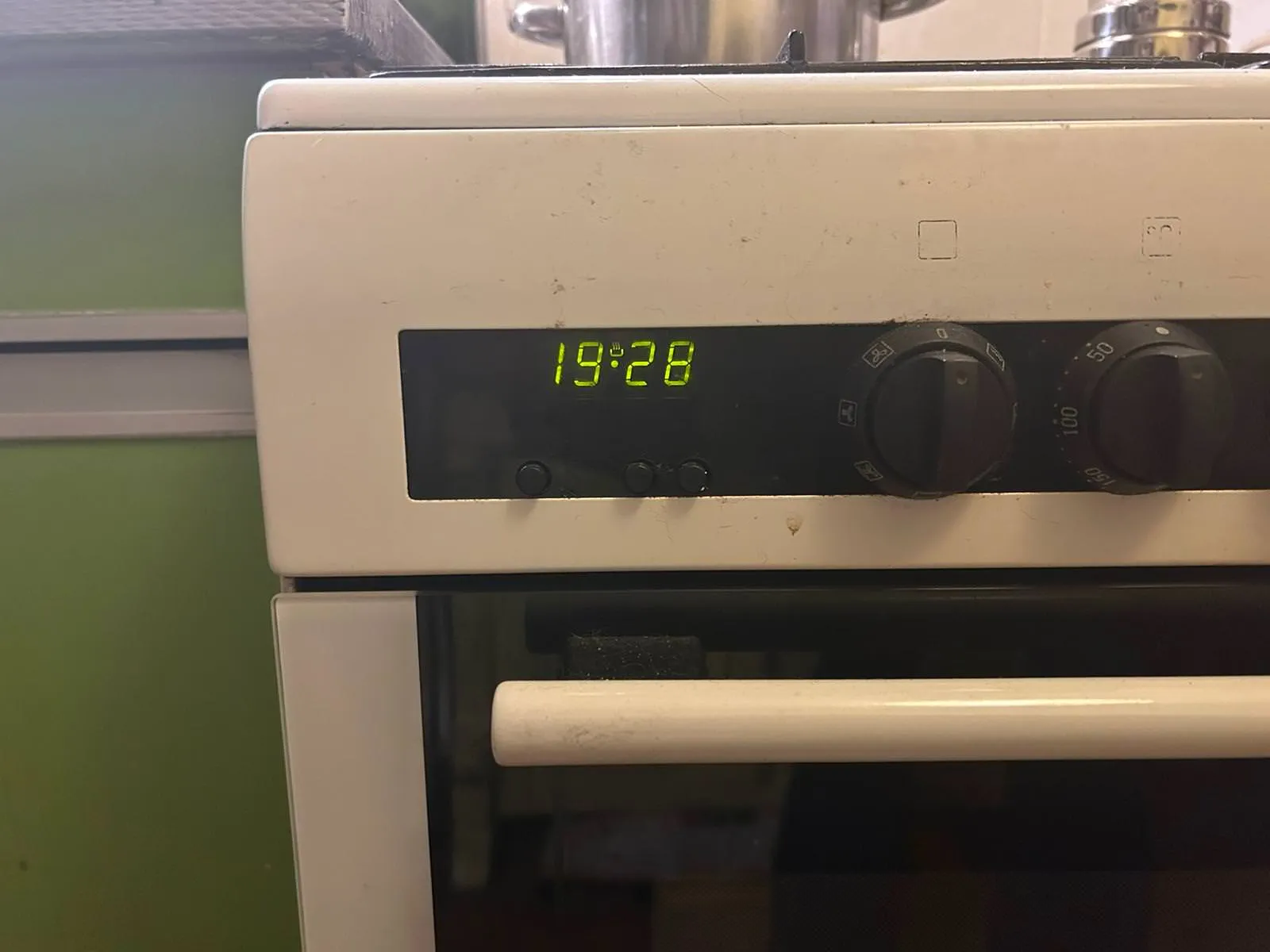 A digital clock on a stove indicates that the time is 19:28. 