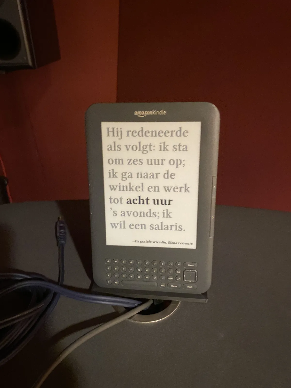 An old e-reader with a literary quote on it, in Dutch. One of the time stamps (8 o’clock) in this quote is highlighted. The quote says, translated: He reasoned as follows: I get up at 6 o’clock, and work until 8 o’clock in the evening; I want a salary.