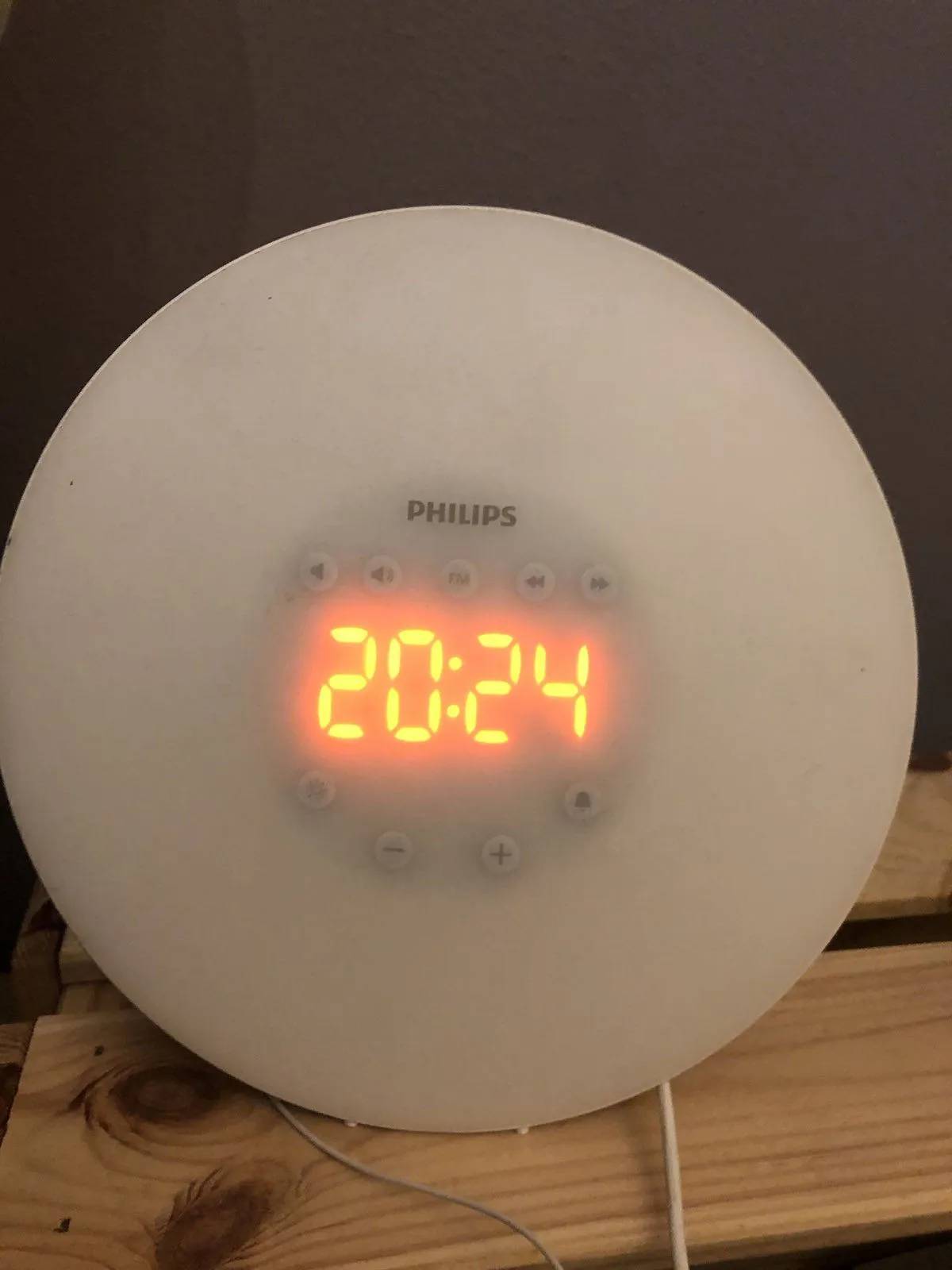 A round white philips clock. In the middle there are bright red digits. They say it is 20:24.