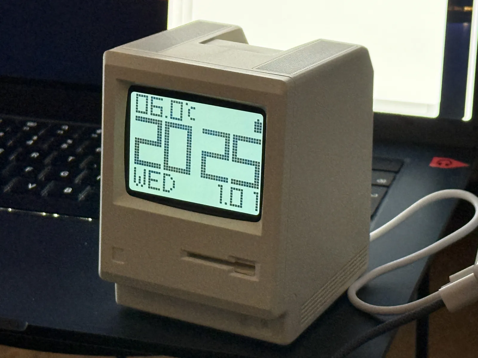 A little table clock in the shape of an old apple macintosh computer, which says 20:25 on its display.